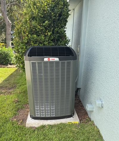 A wooden deck with chairs and a table on it surrounded by trees.