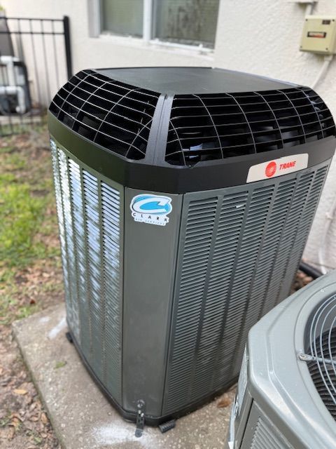 A wooden deck with chairs and a table on it surrounded by trees.