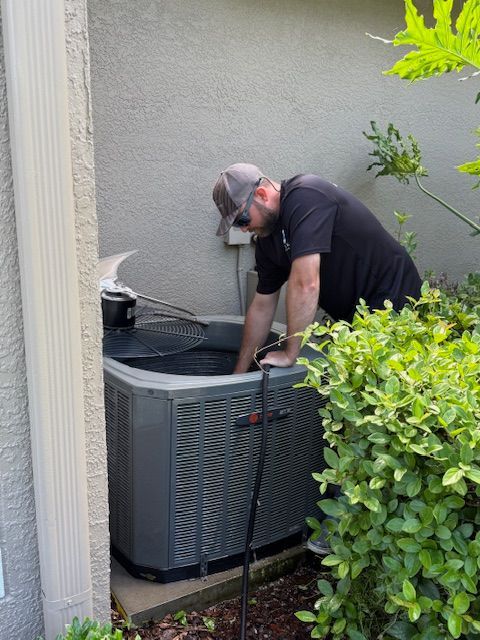 A wooden deck with chairs and a table on it surrounded by trees.