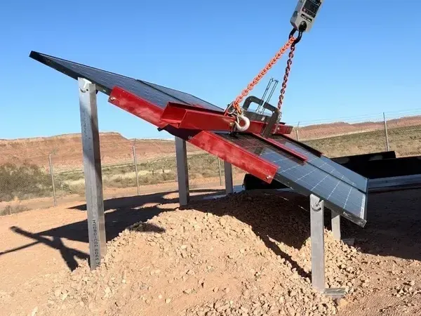 A crane is lifting a metal structure in the desert