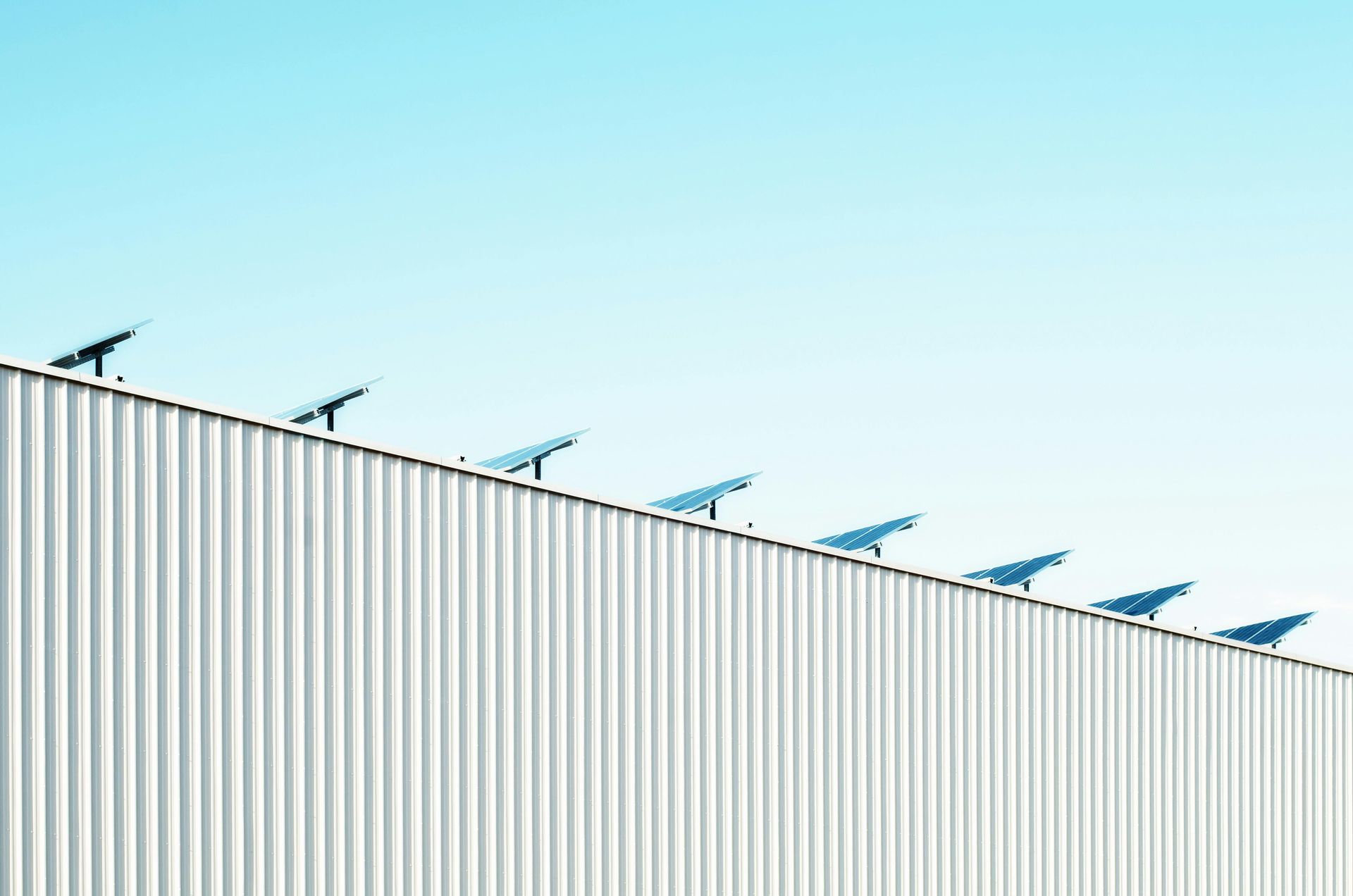 A row of solar panels on the roof of a building.