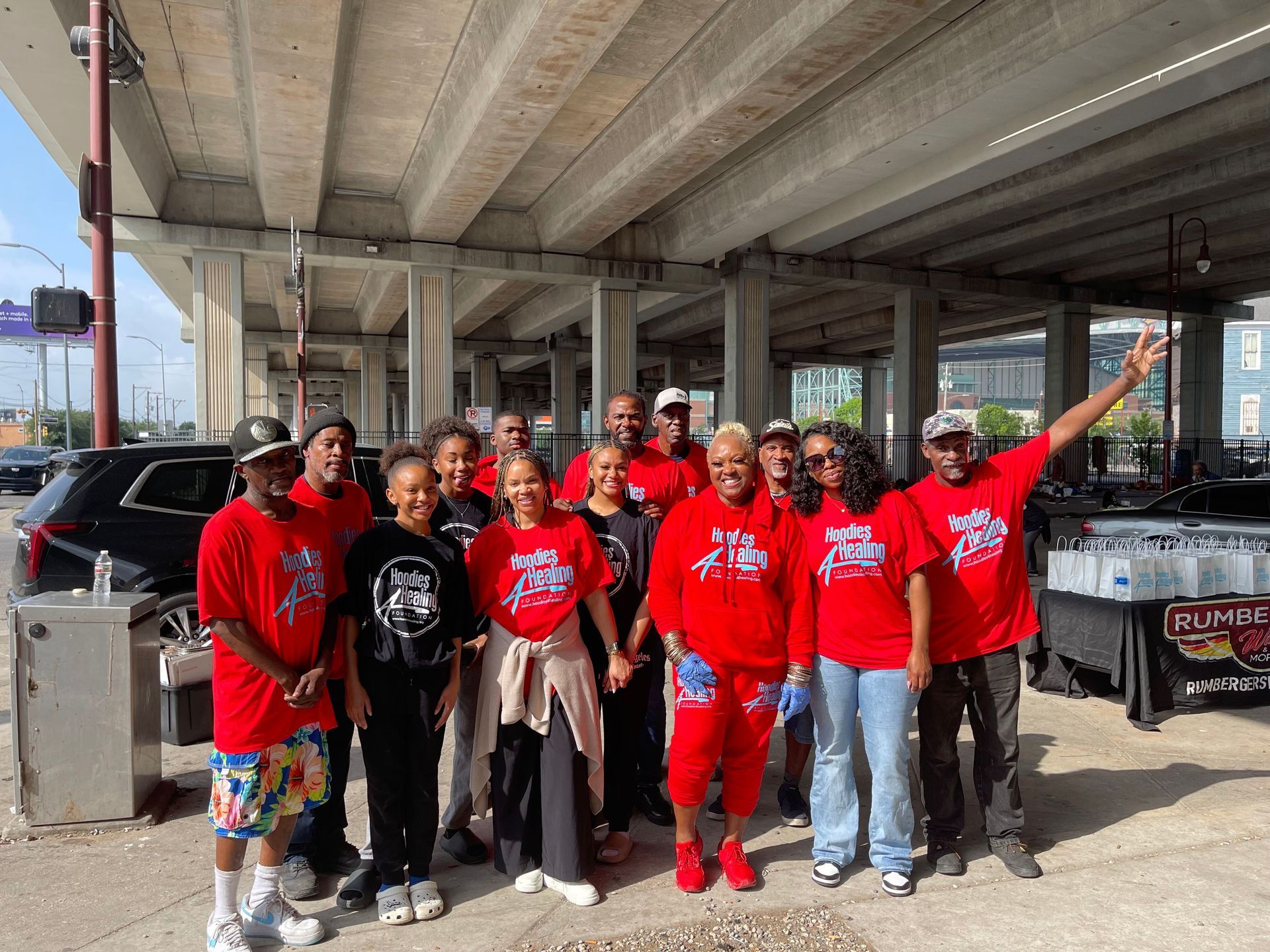 A group of people are posing for a picture under a bridge.