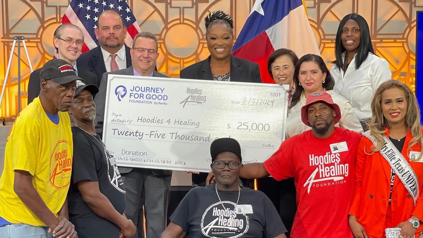 A group of people are posing for a picture while holding a large check.