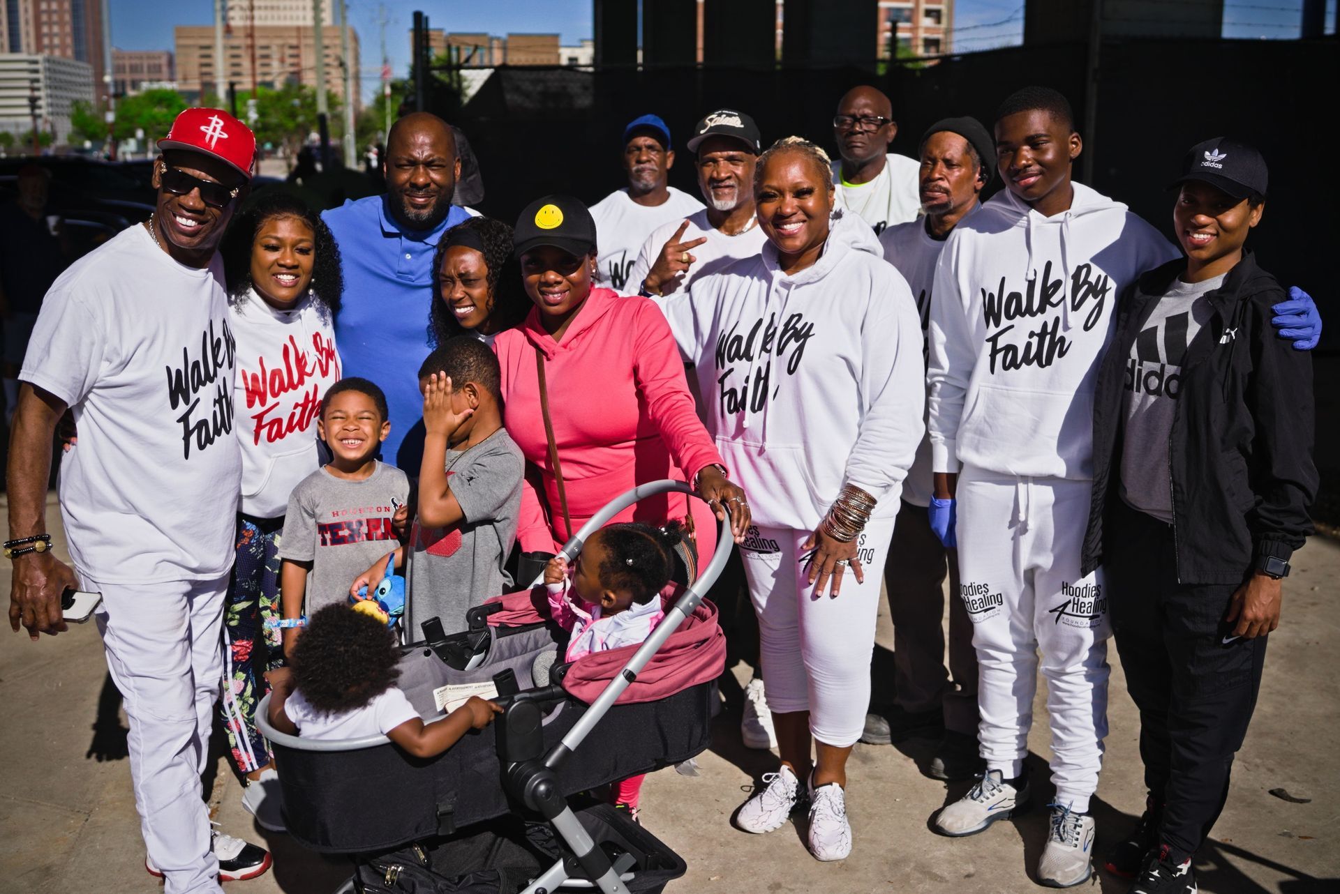 A group of people are posing for a picture with a baby in a stroller.