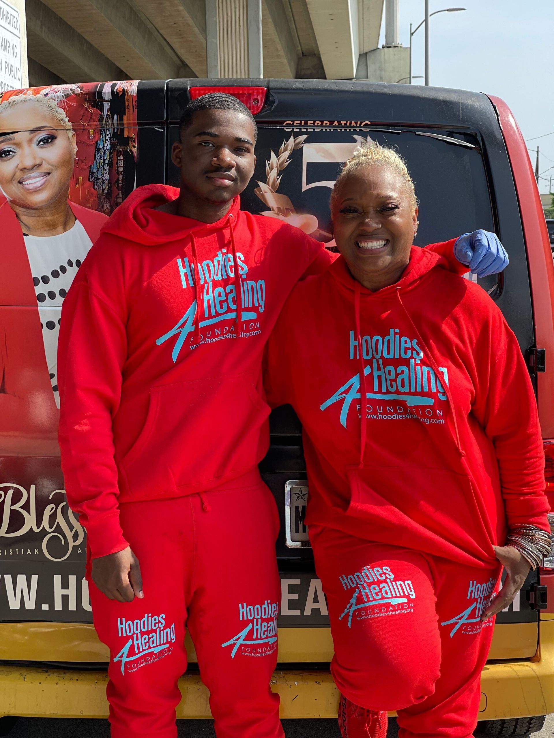 A man and a woman are standing next to each other in front of a van.