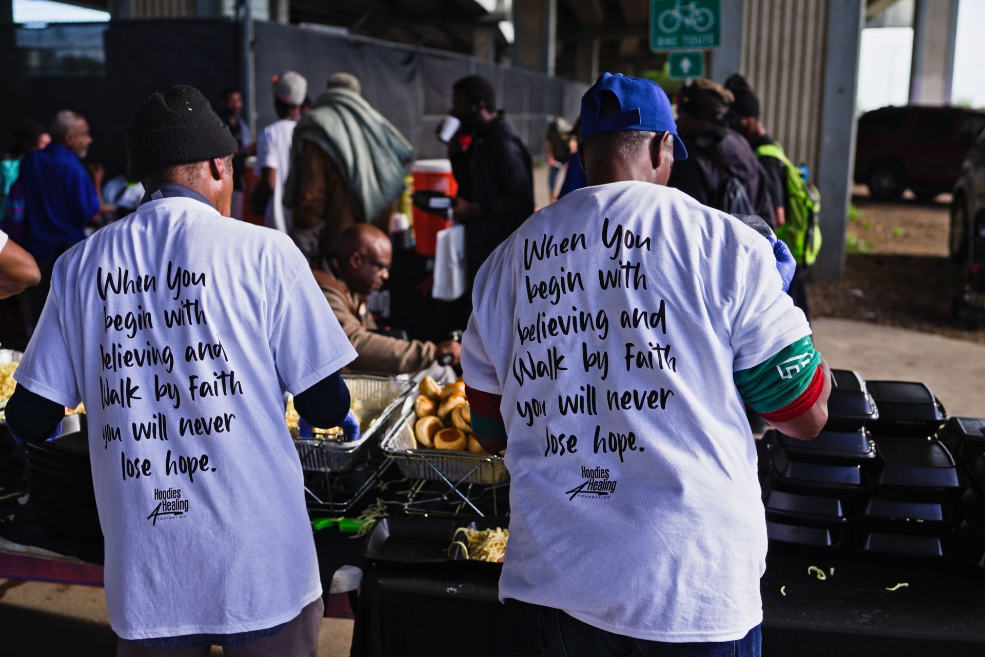 Two men wearing white shirts that say 