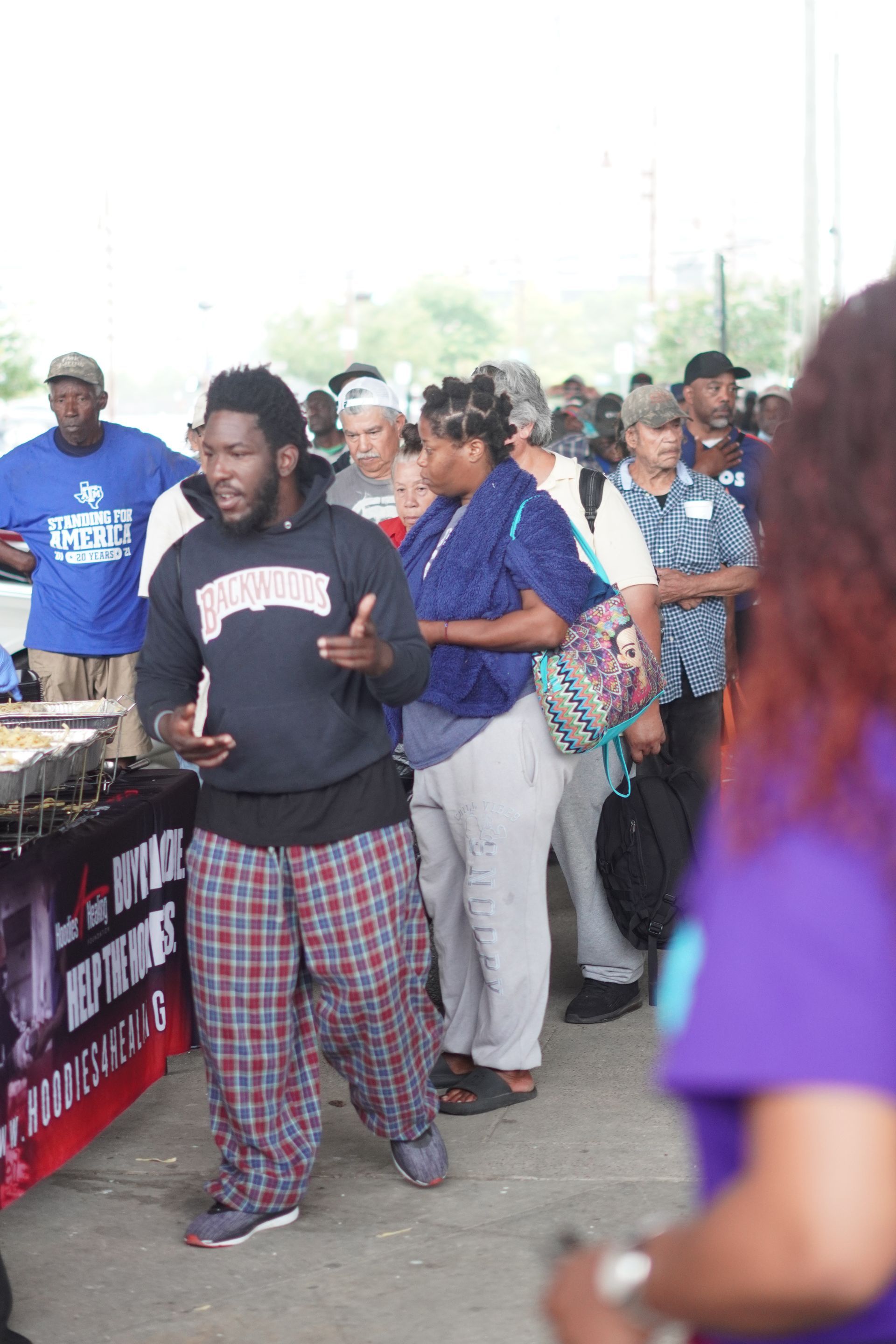 A man in pajamas is standing in front of a crowd of people.