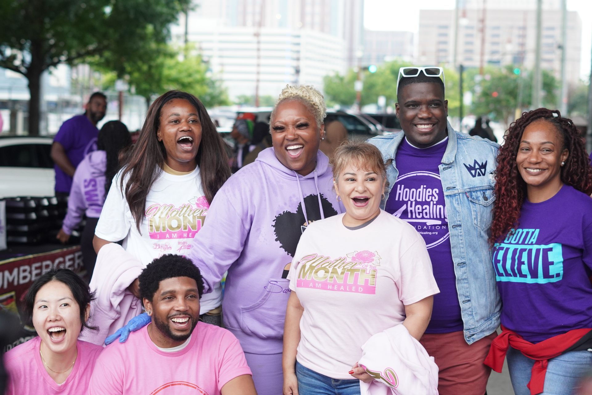 A group of people wearing pink and purple shirts are posing for a picture.