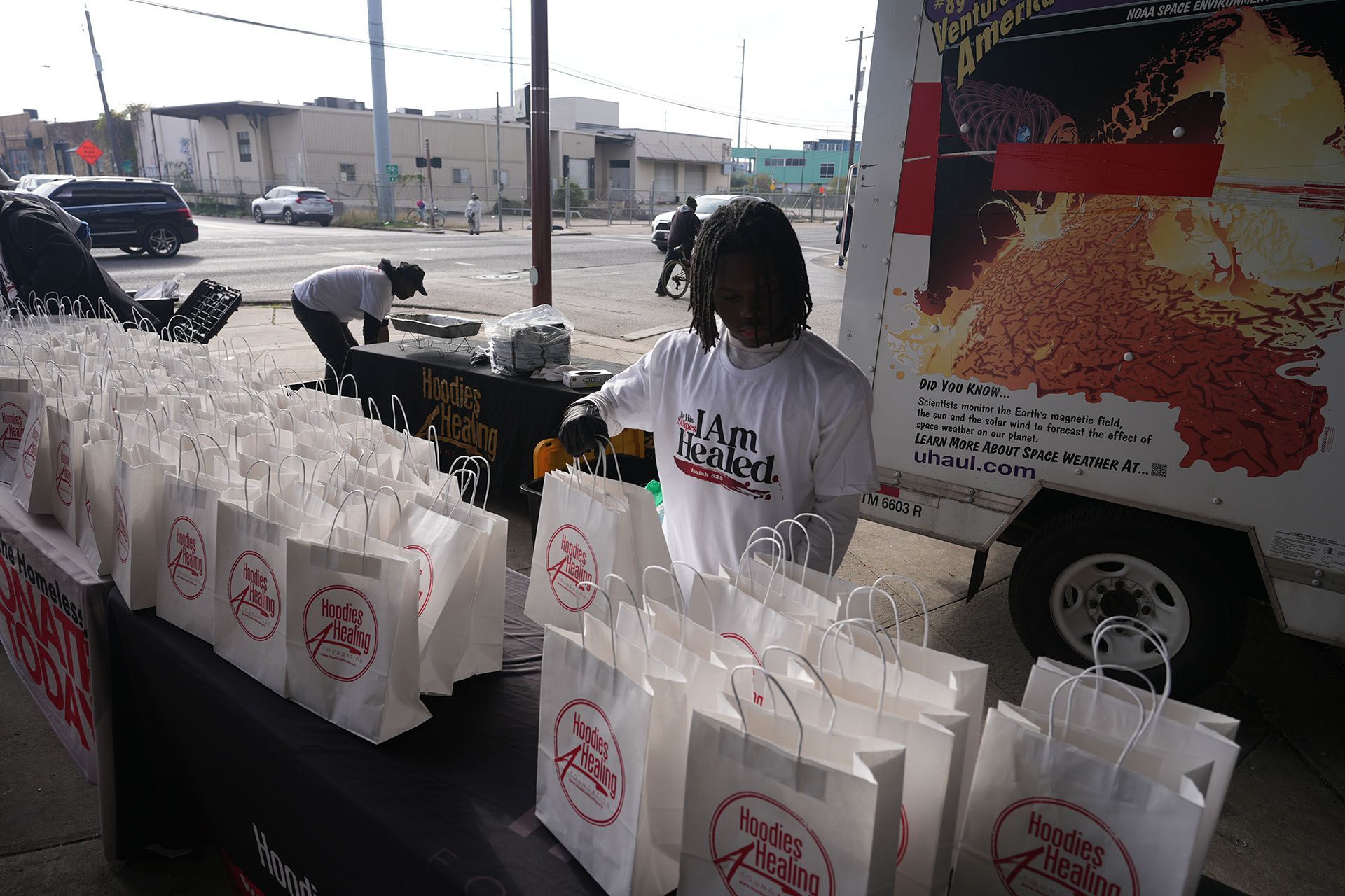 A man standing in front of a table full of bags that say jagi