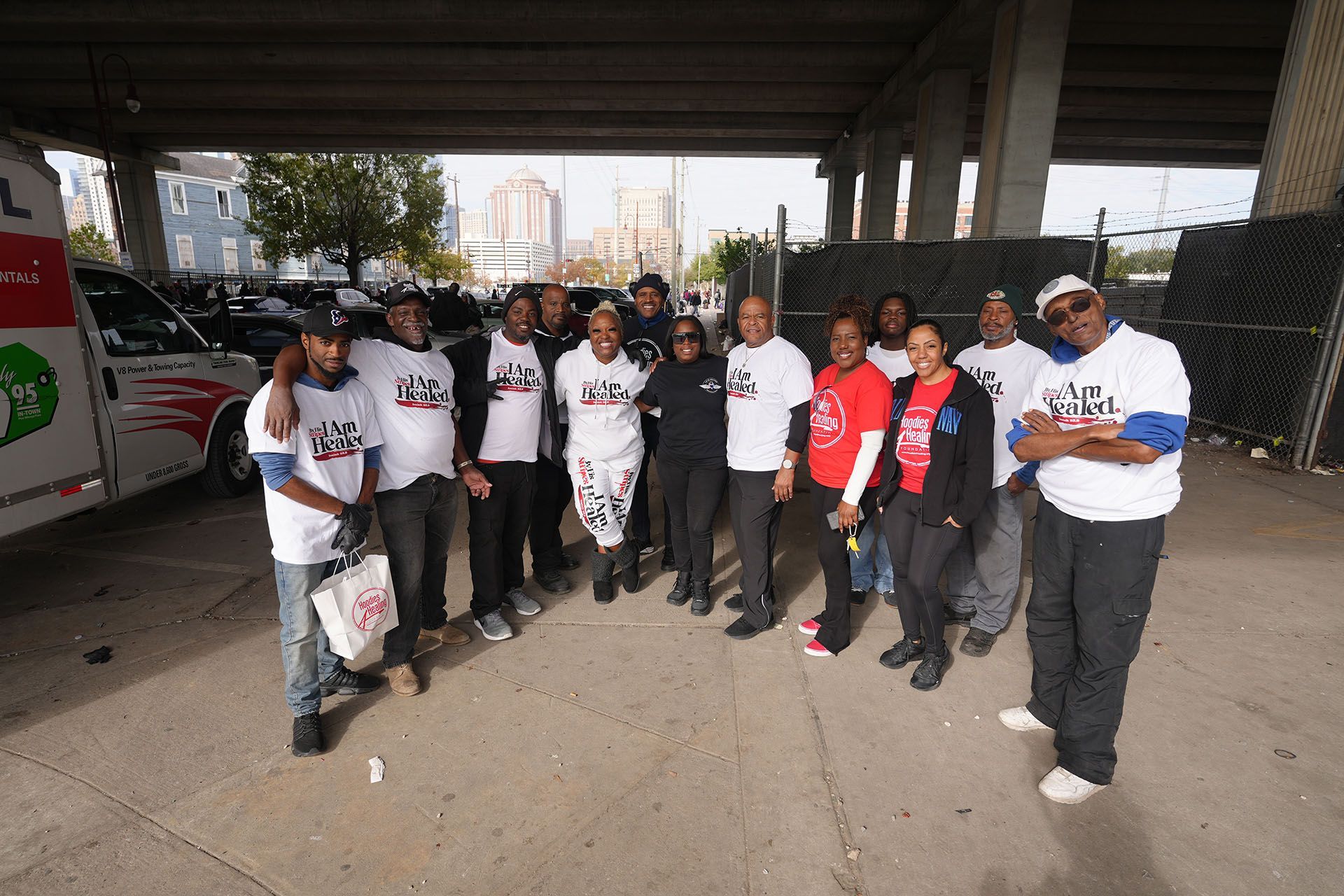 A group of people are posing for a picture under a bridge.