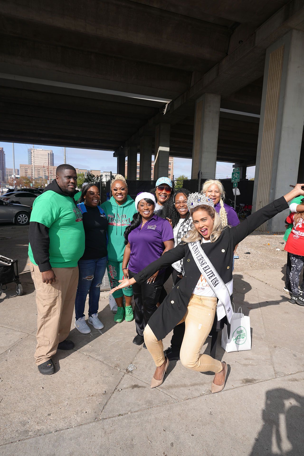 A group of people are posing for a picture under a bridge.