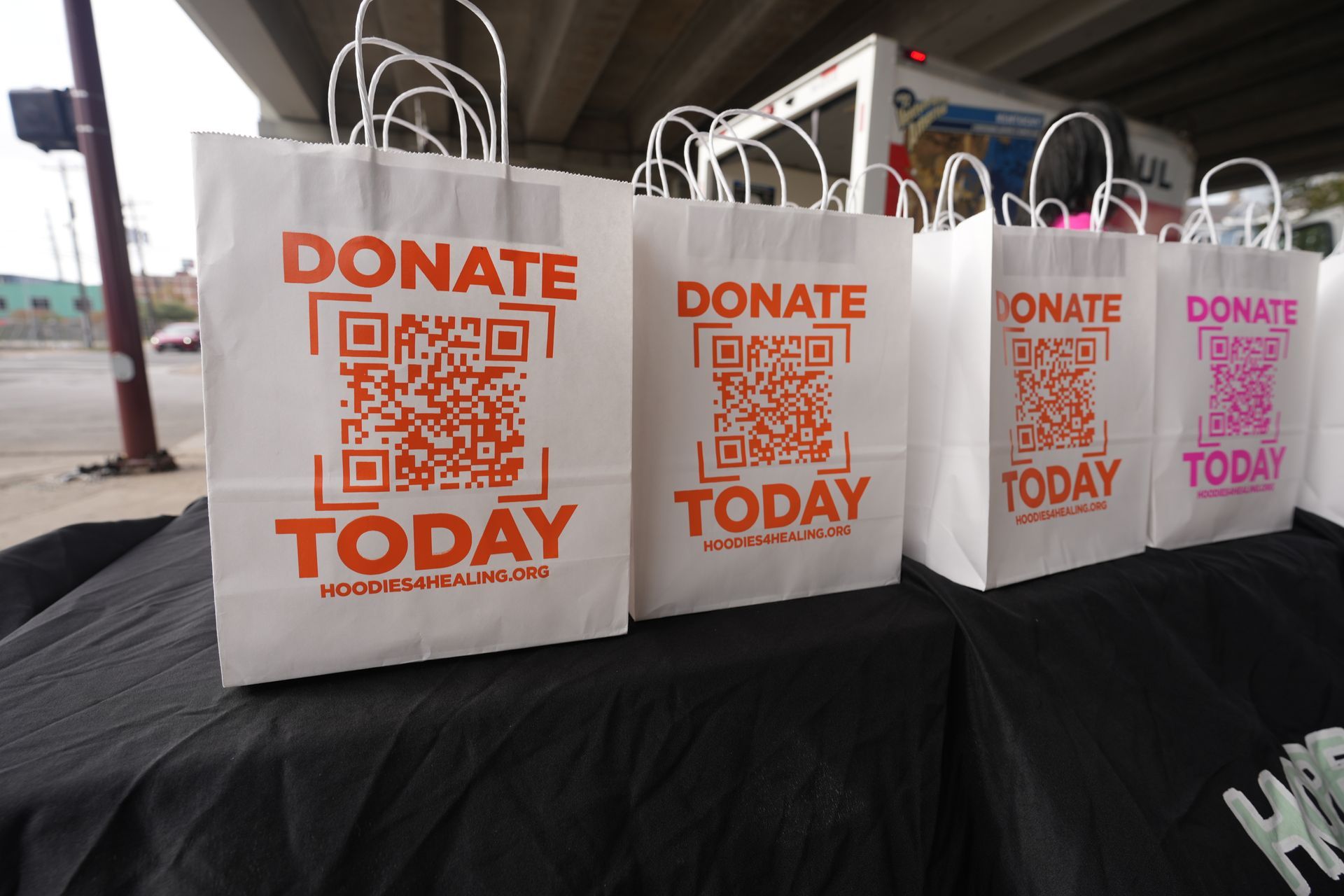 A row of donate today bags on a table