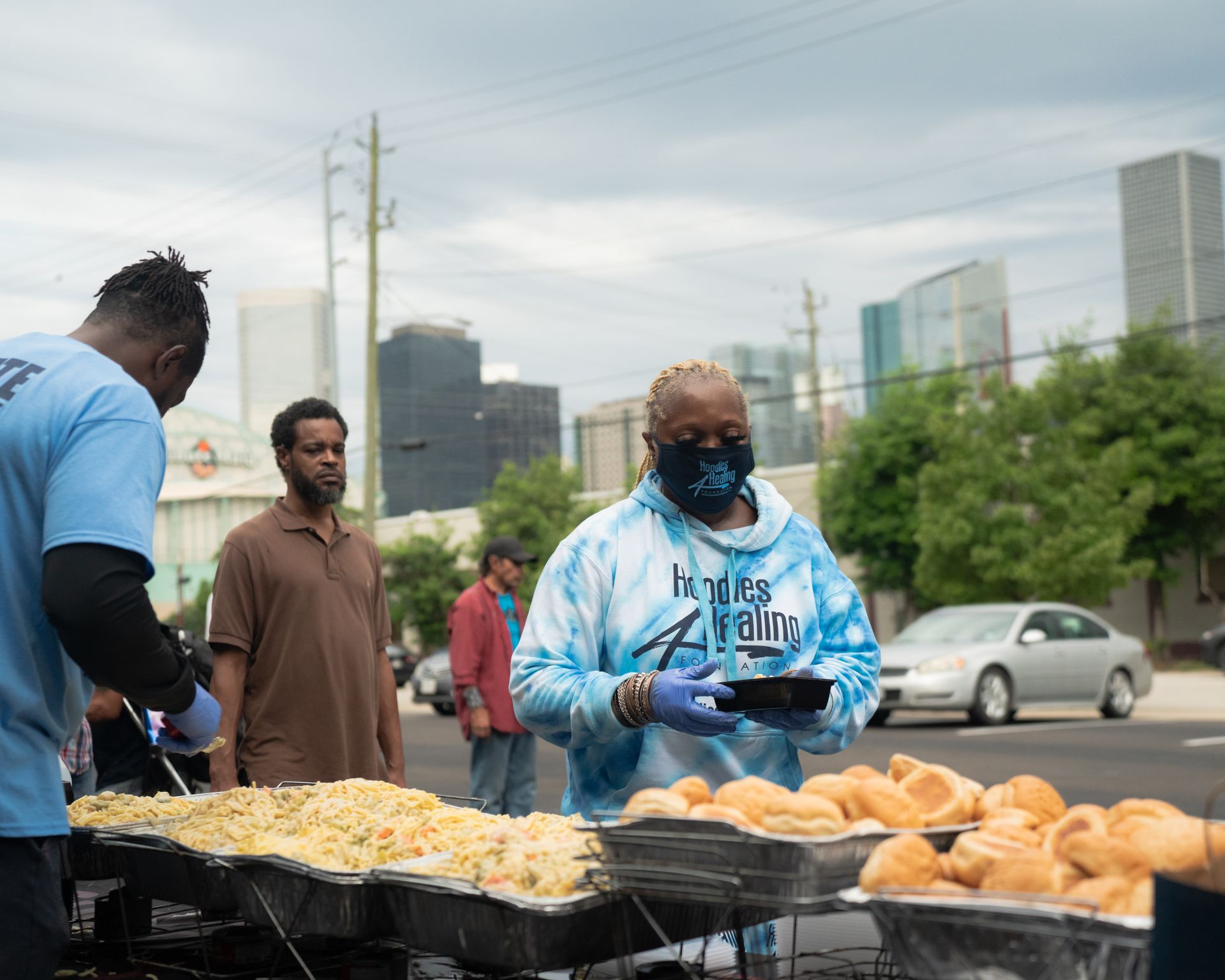A man wearing a mask is standing in front of a table of food.