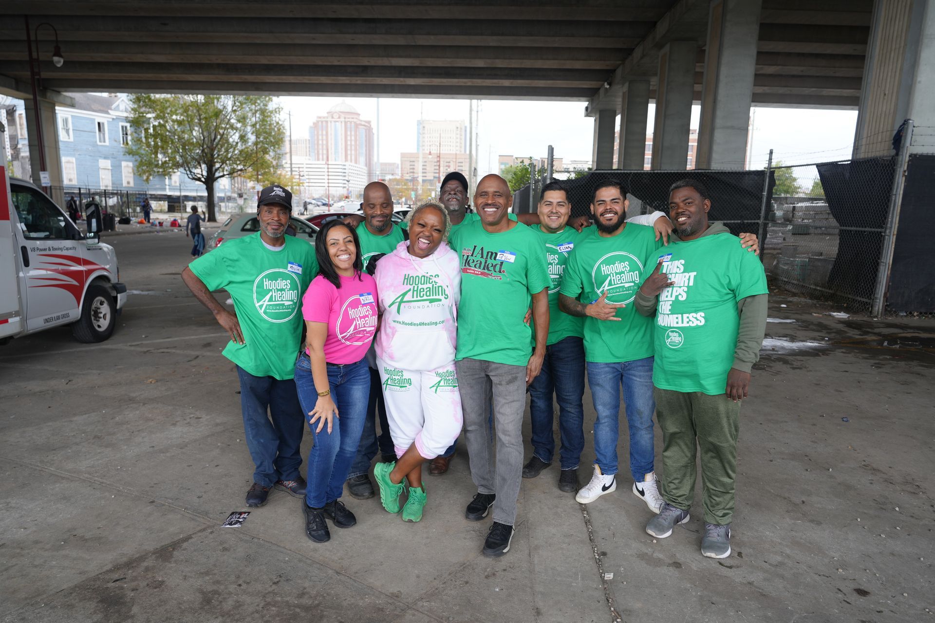 A group of people wearing green shirts are posing for a picture.
