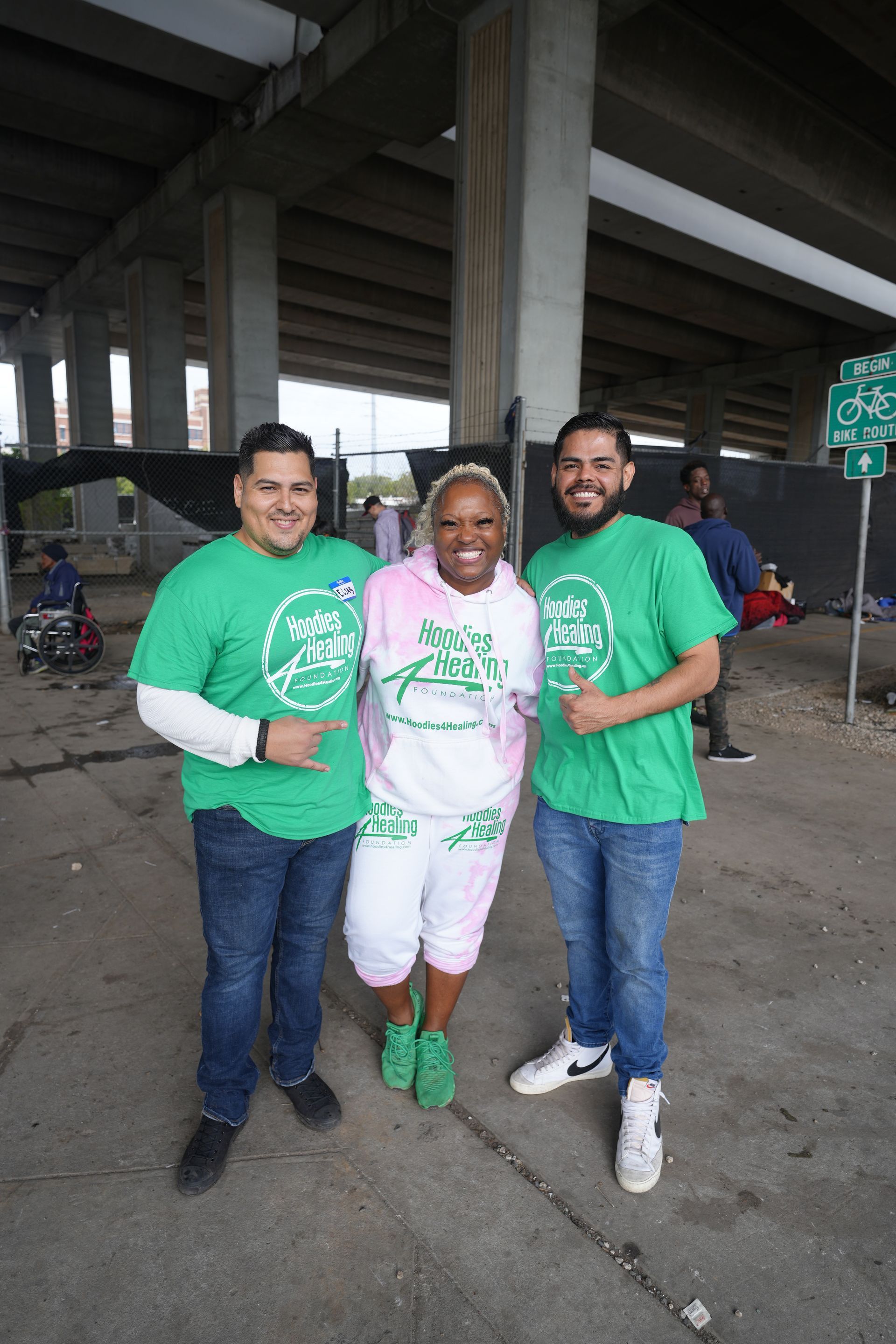 A woman in a white hoodie is standing in front of a van.