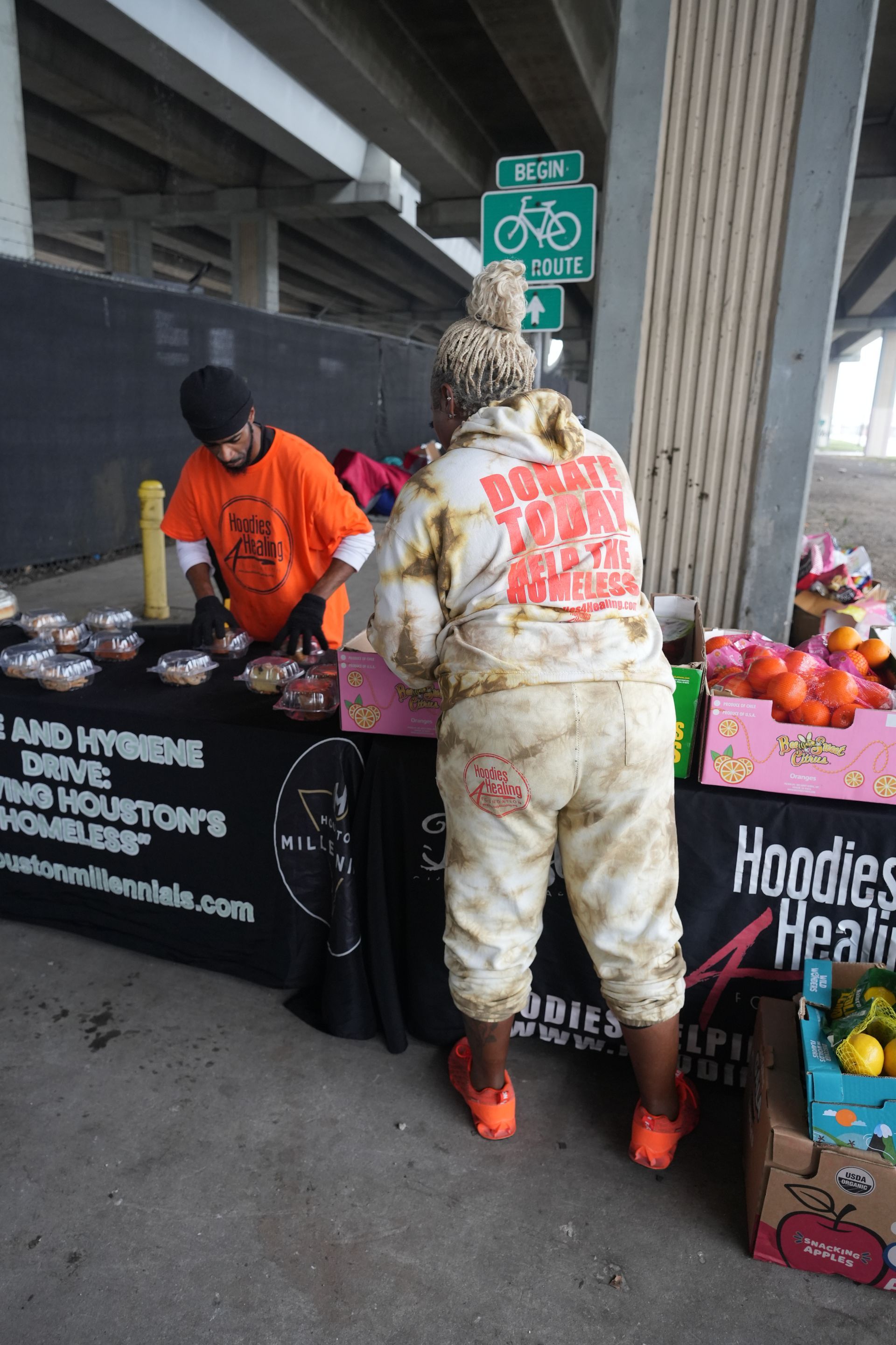 A woman standing in front of a table that says hoodies realty