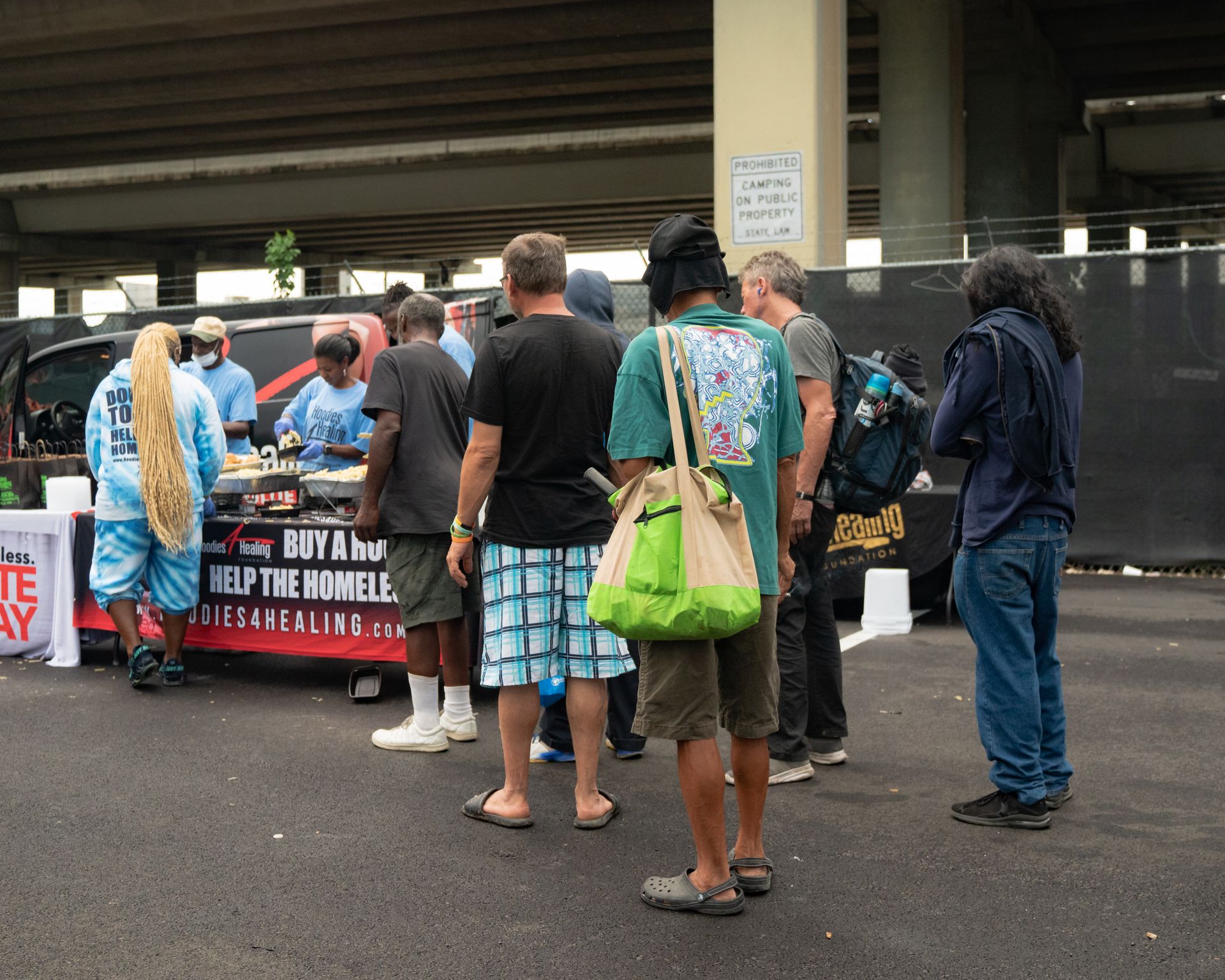 A group of people standing in front of a sign that says buy a van