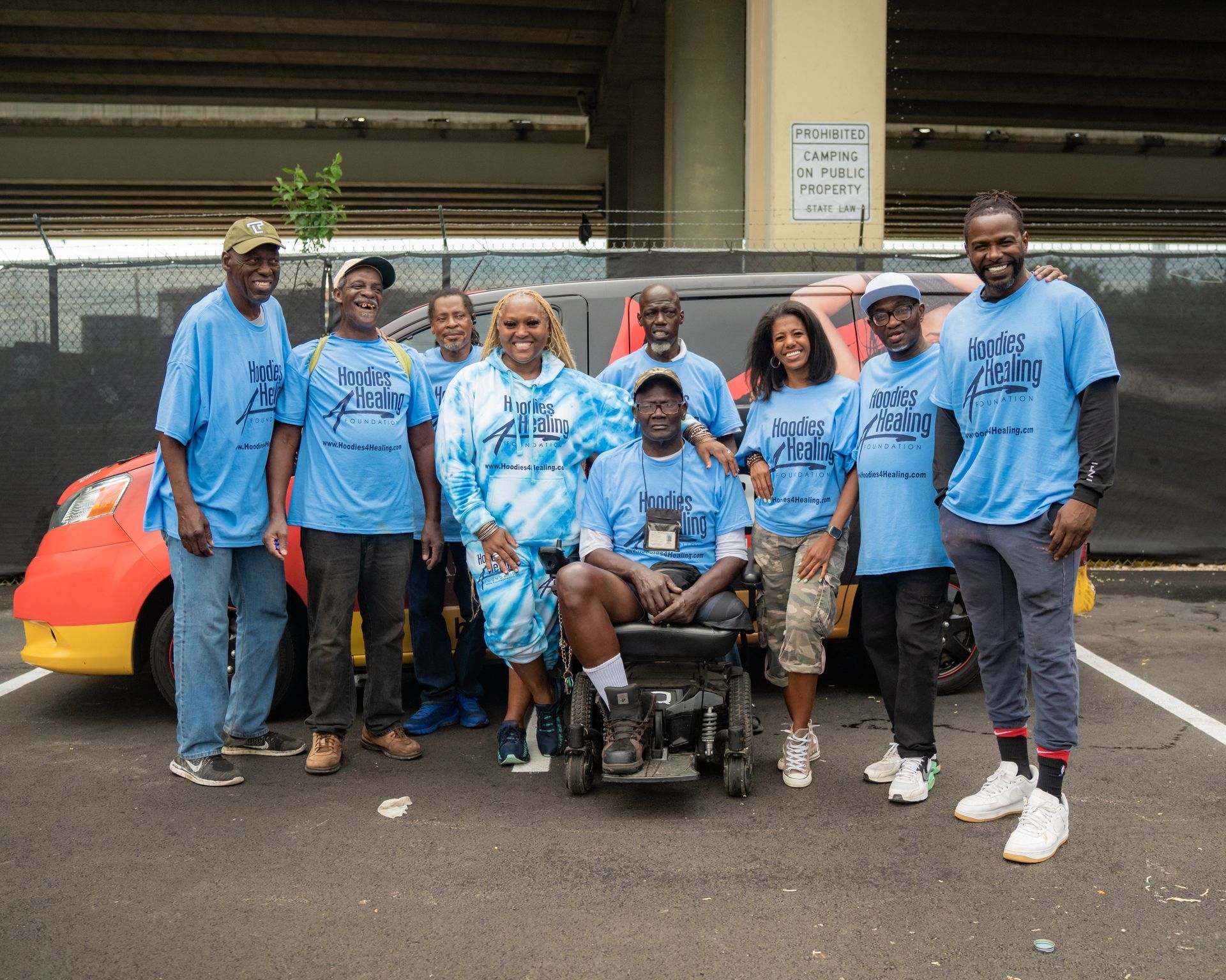 A group of people are posing for a picture in a parking lot.