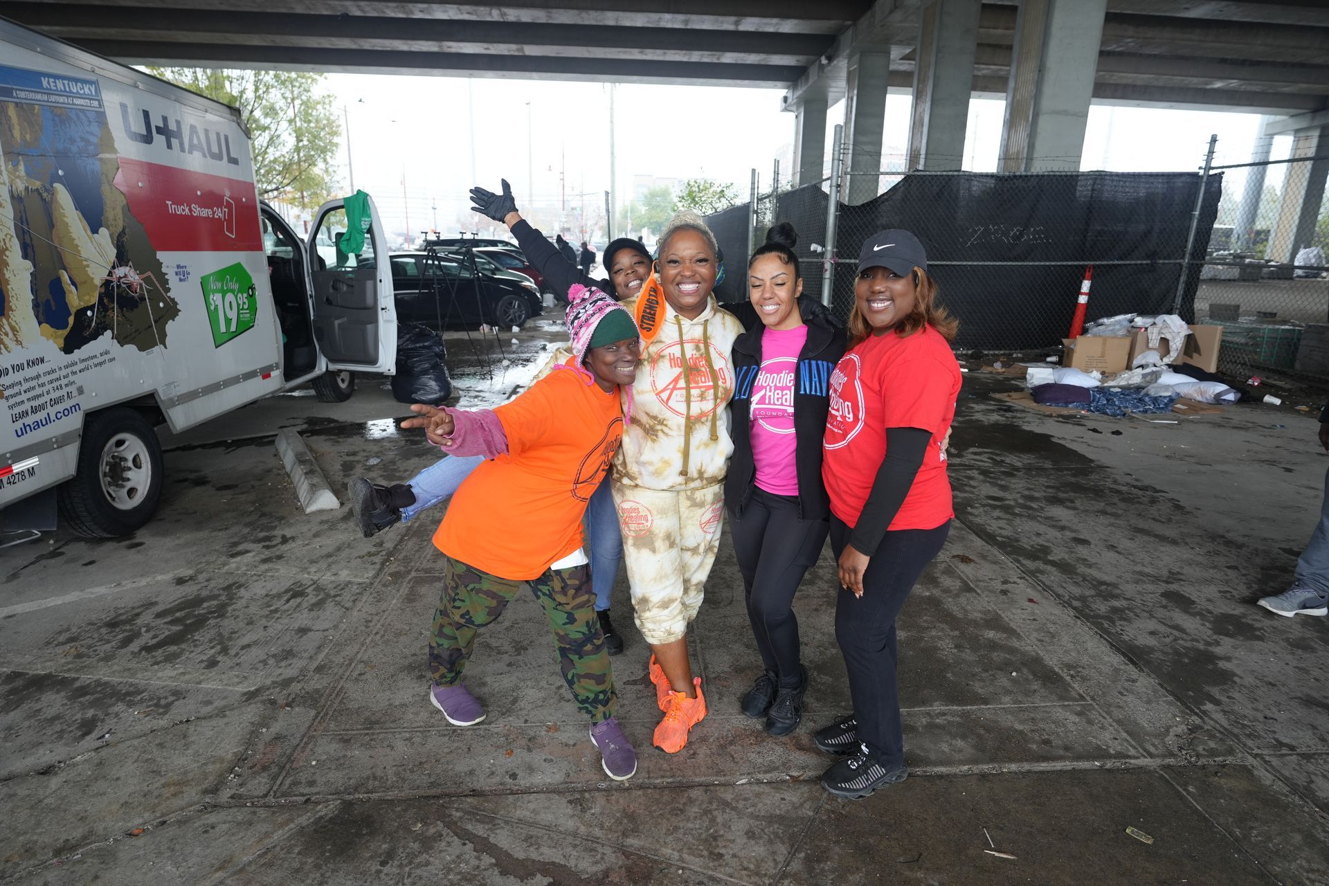 A group of people posing for a picture in a parking lot