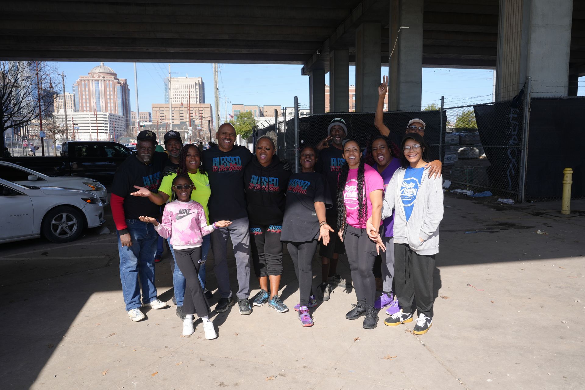 A group of people are standing around a table under a bridge.