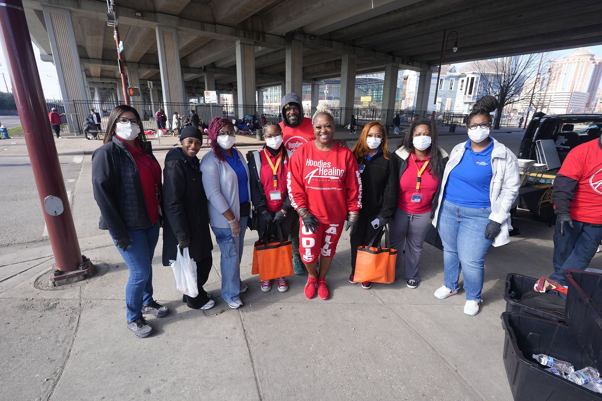 A group of people are posing for a picture under a bridge.