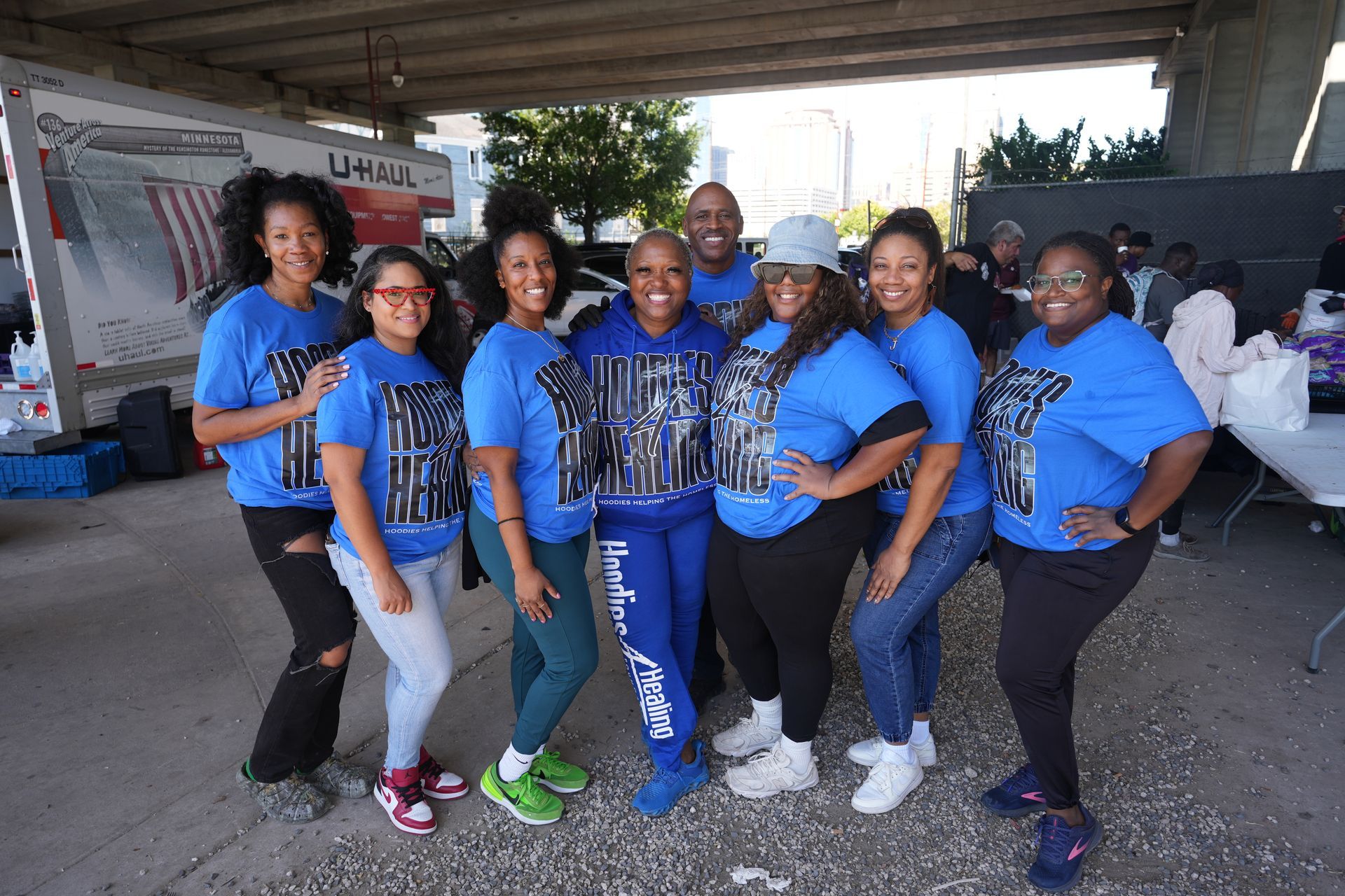 A group of people are posing for a picture under a bridge.