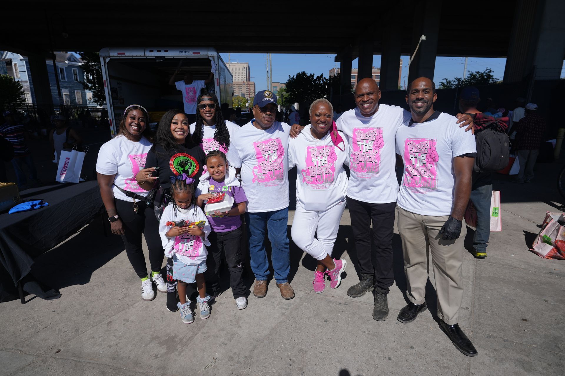 A group of people are posing for a picture under a bridge.