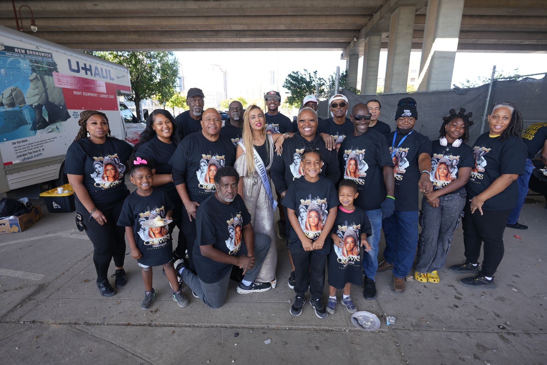 A group of people are posing for a picture under a bridge.