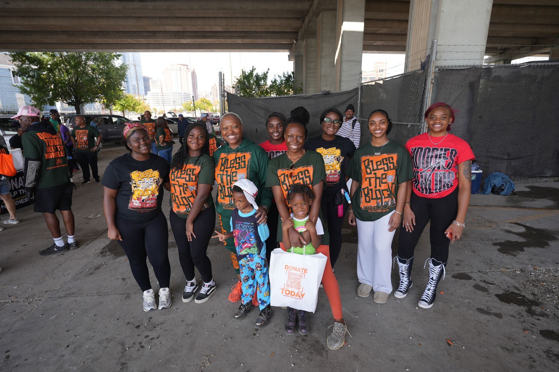 A group of people are posing for a picture under a bridge.