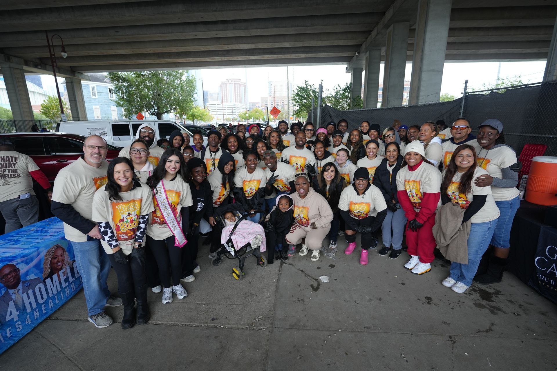 A group of people are posing for a picture under a bridge.