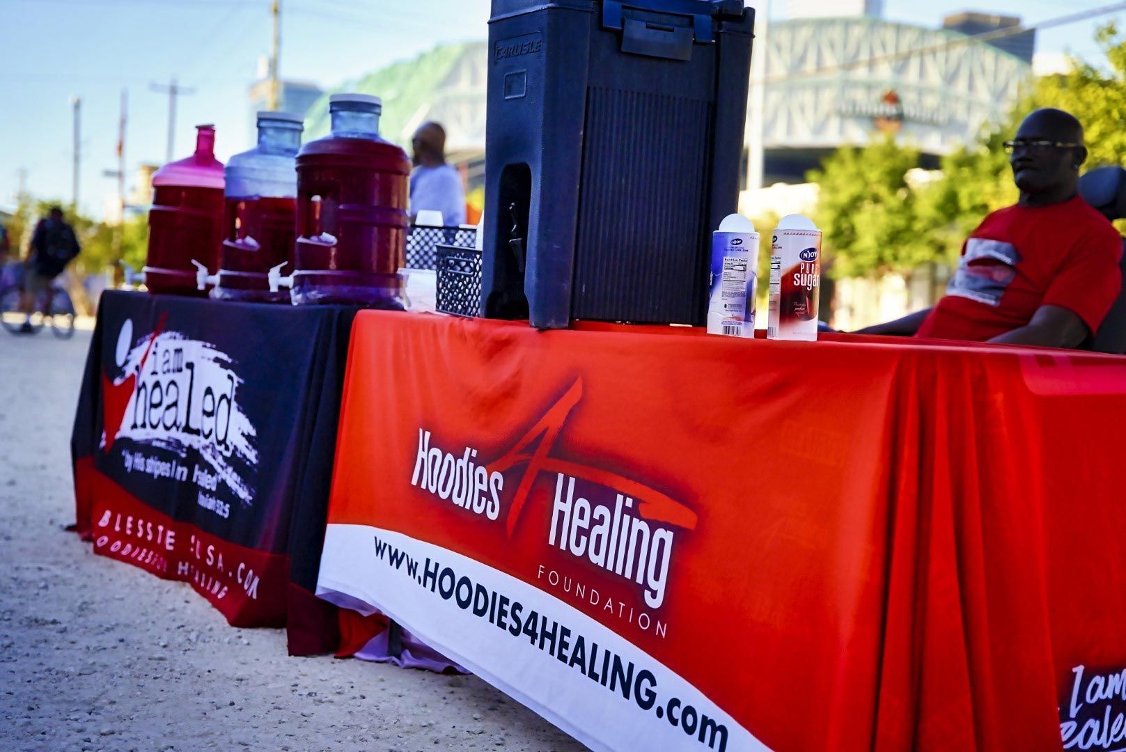 A table with a red table cloth that says hoodies healing