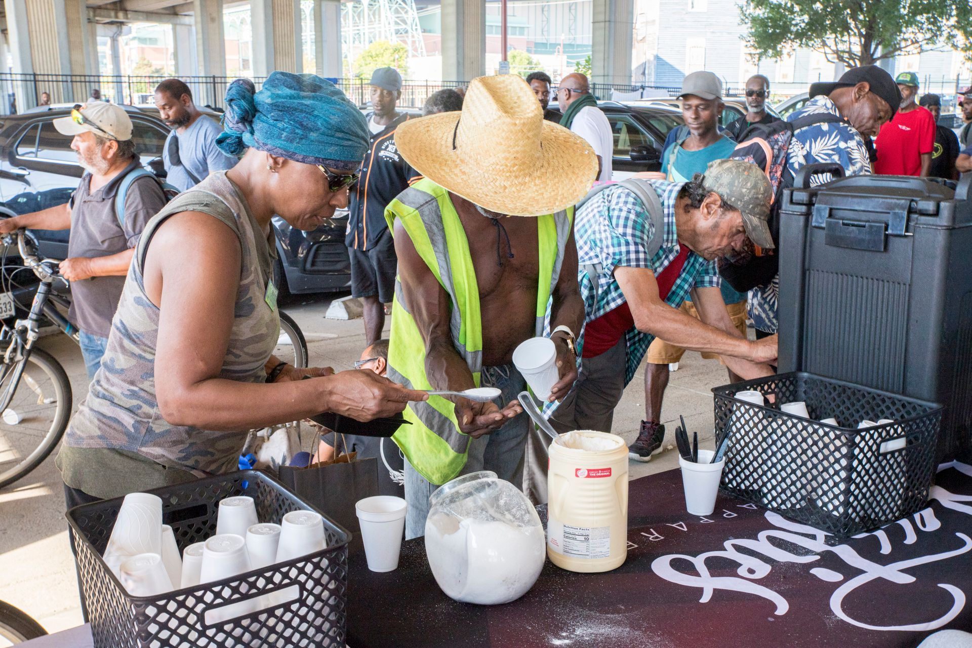 A group of people are standing around a table.