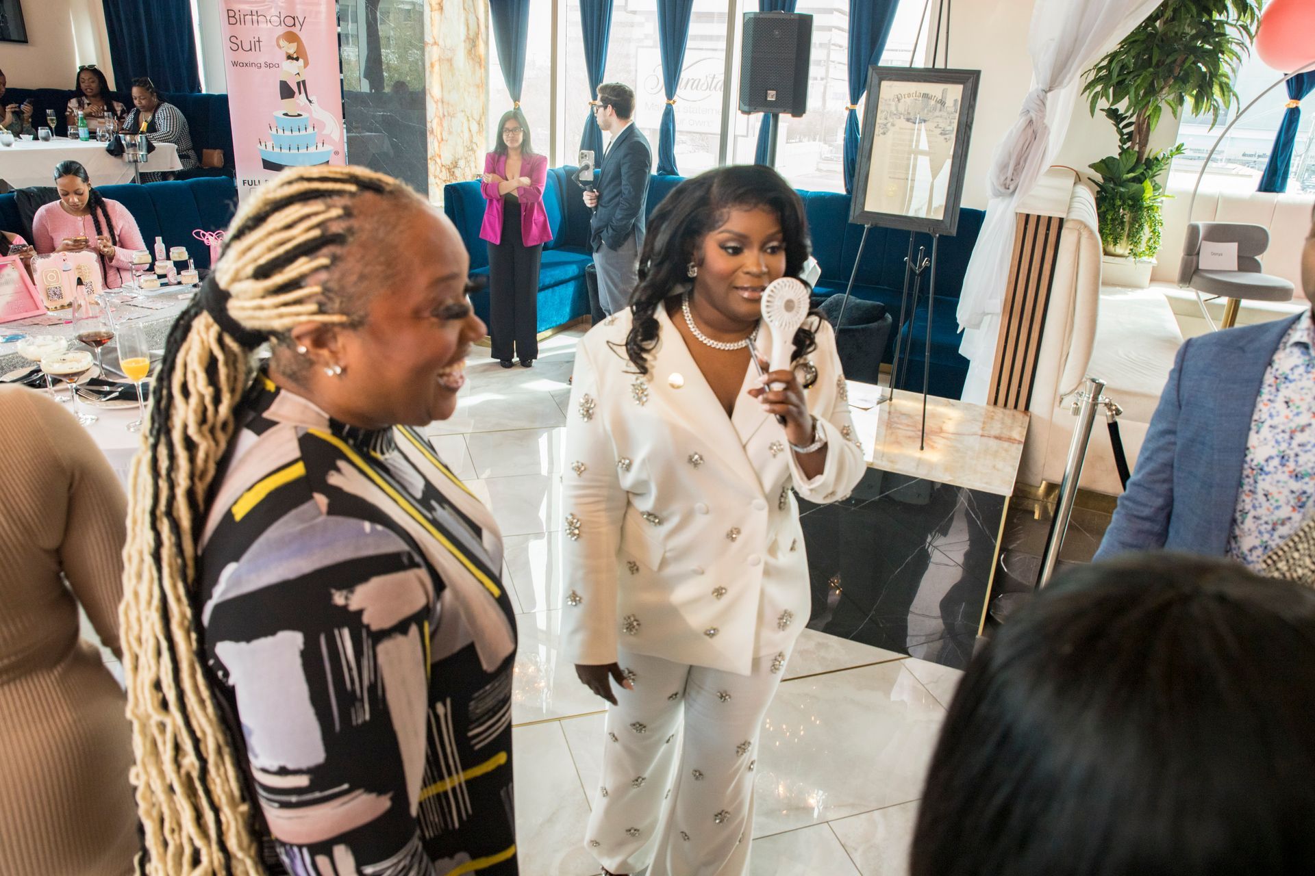 A woman is holding a microphone and talking to a group of people.