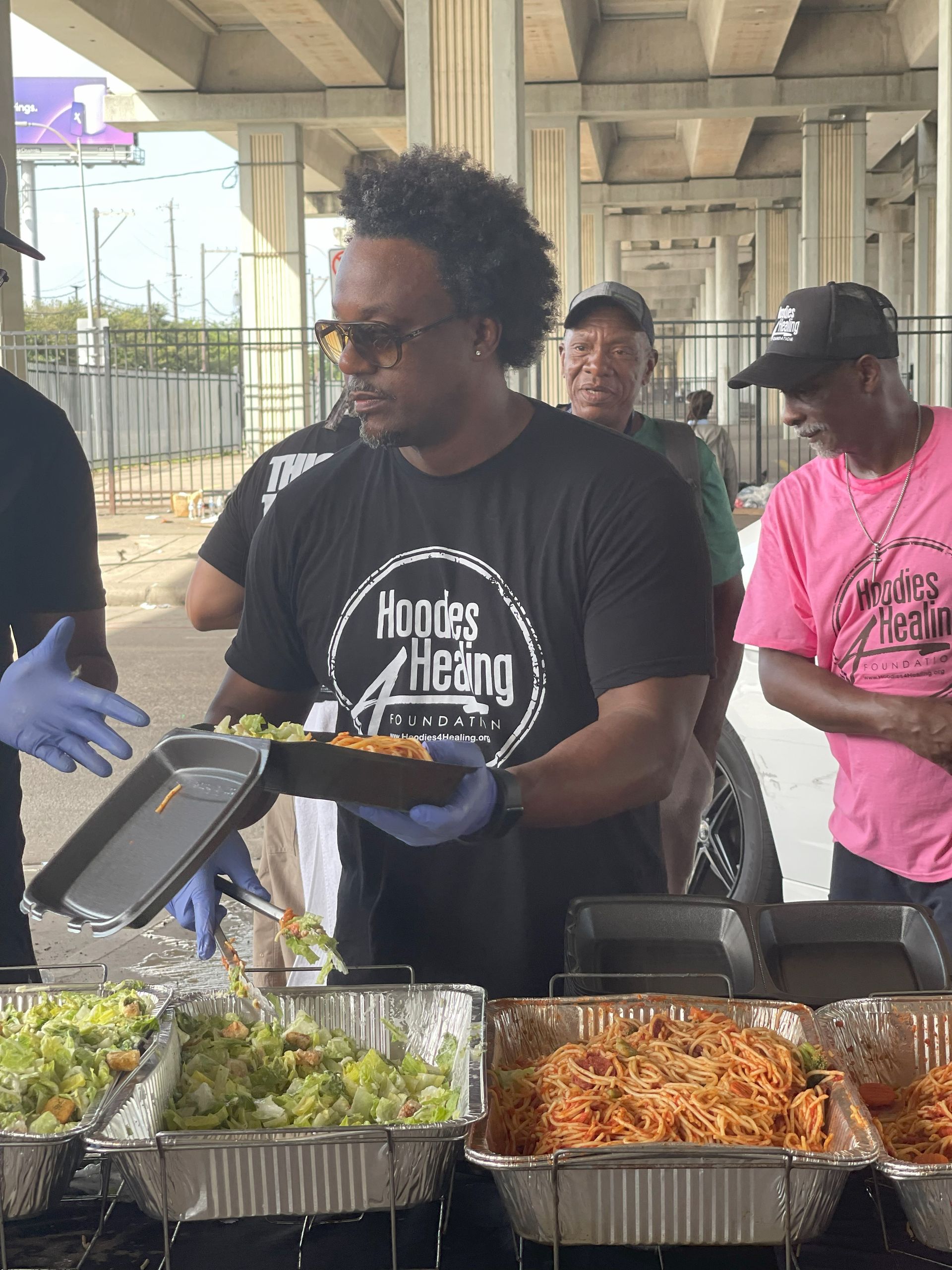 A man in a black shirt is holding a tray of food.