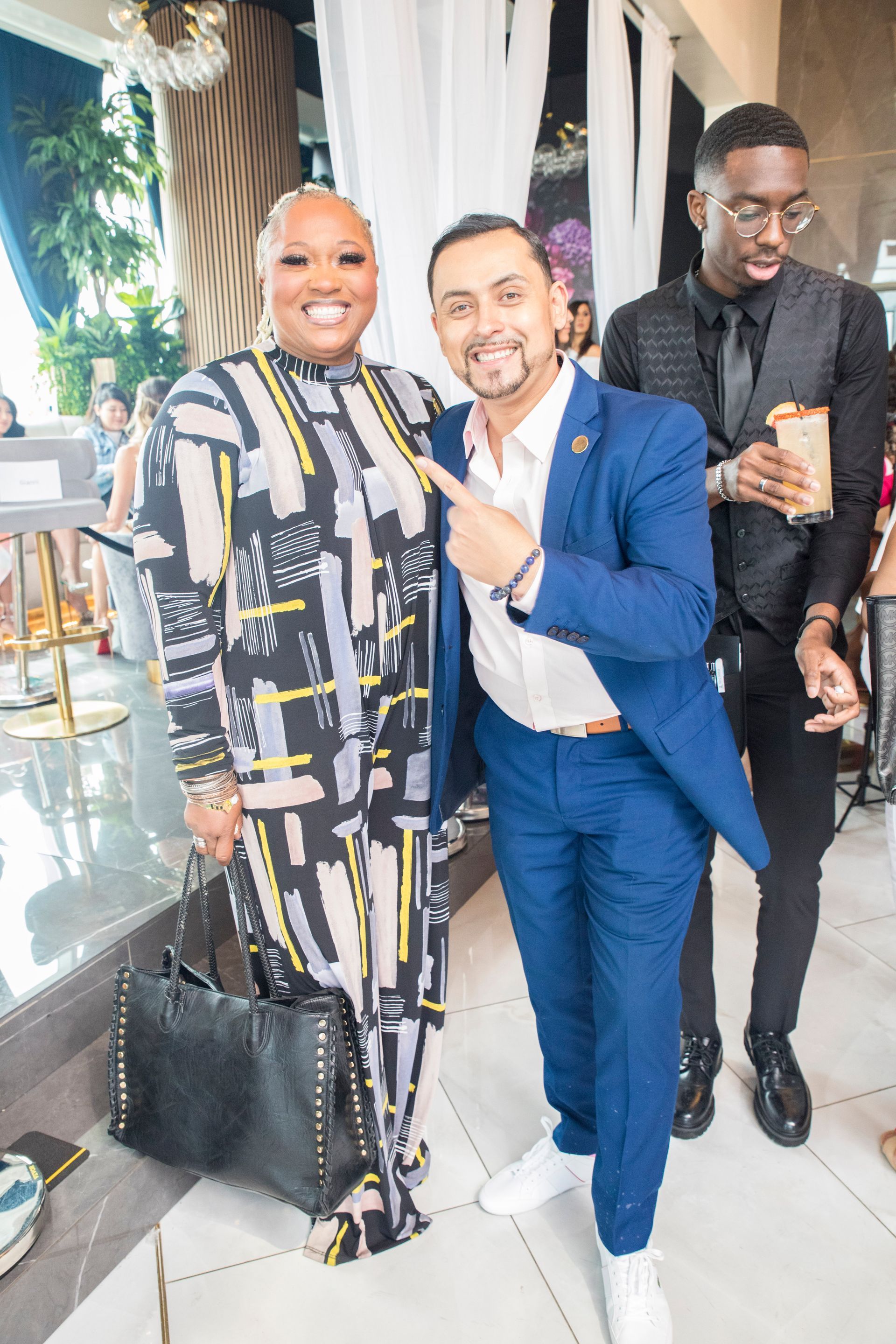 A man in a suit is standing next to a woman in a jumpsuit.