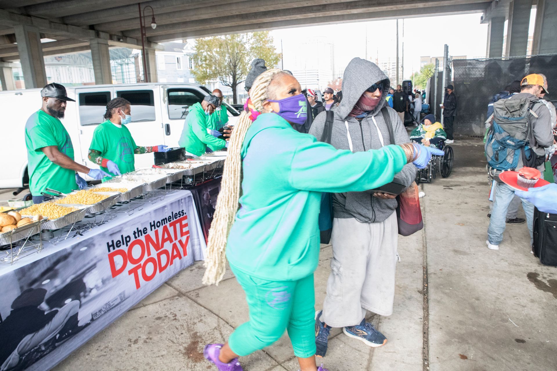 A woman is hugging a man in front of a table that says donate today.