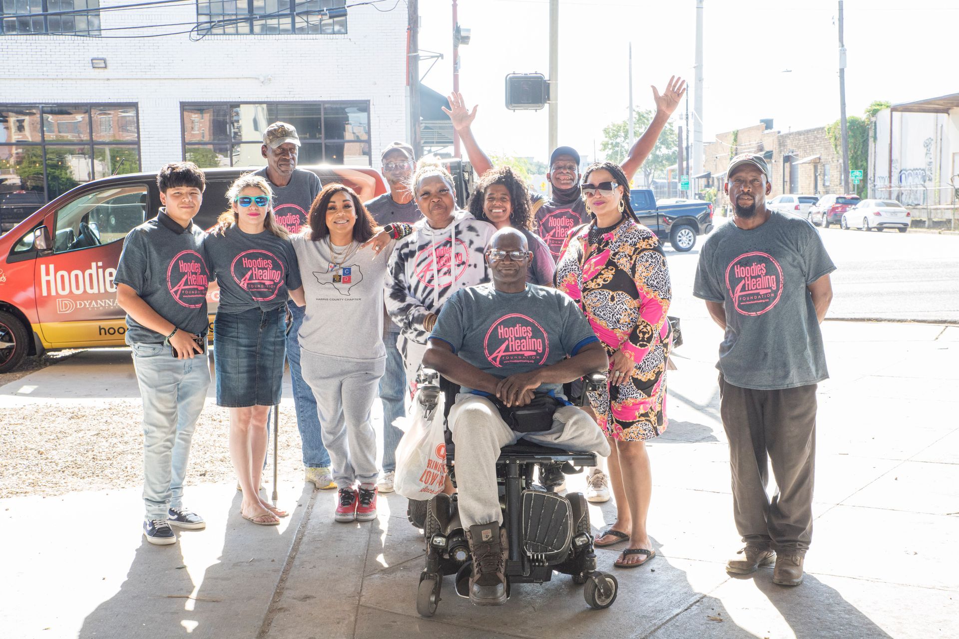 A group of people are posing for a picture with a man in a wheelchair.