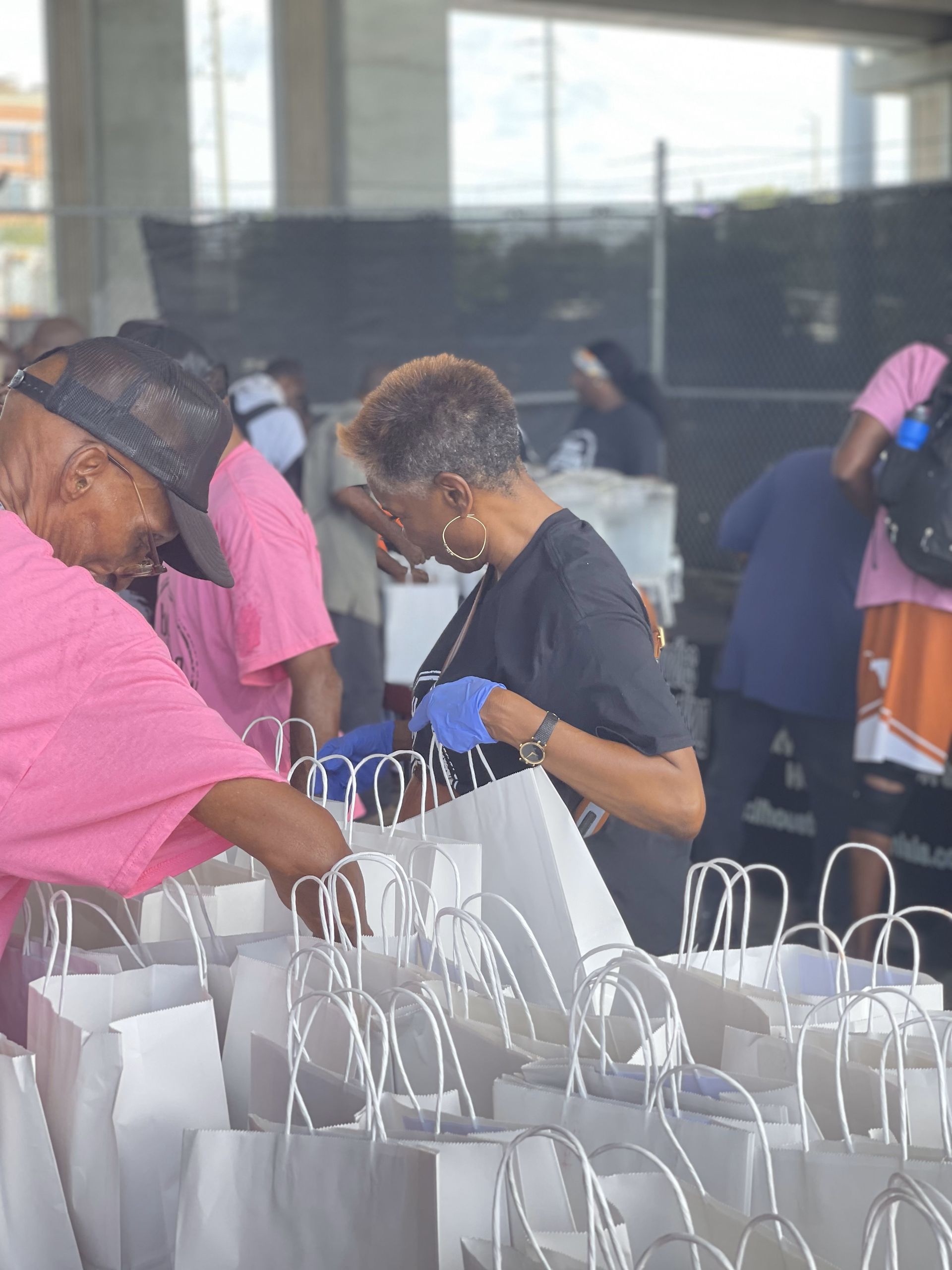 A group of people are standing around a row of bags.