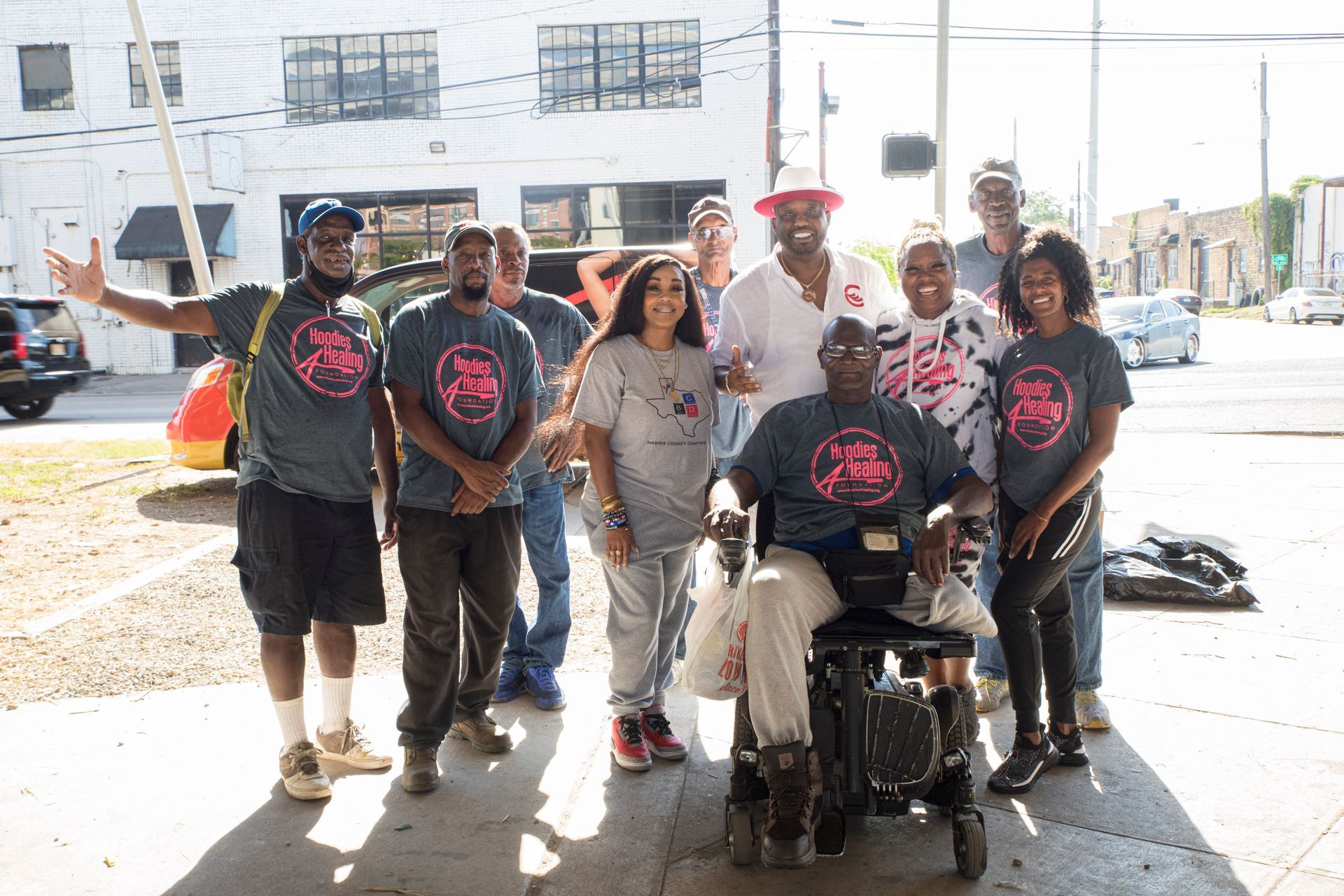 A group of people posing for a picture with one man in a wheelchair