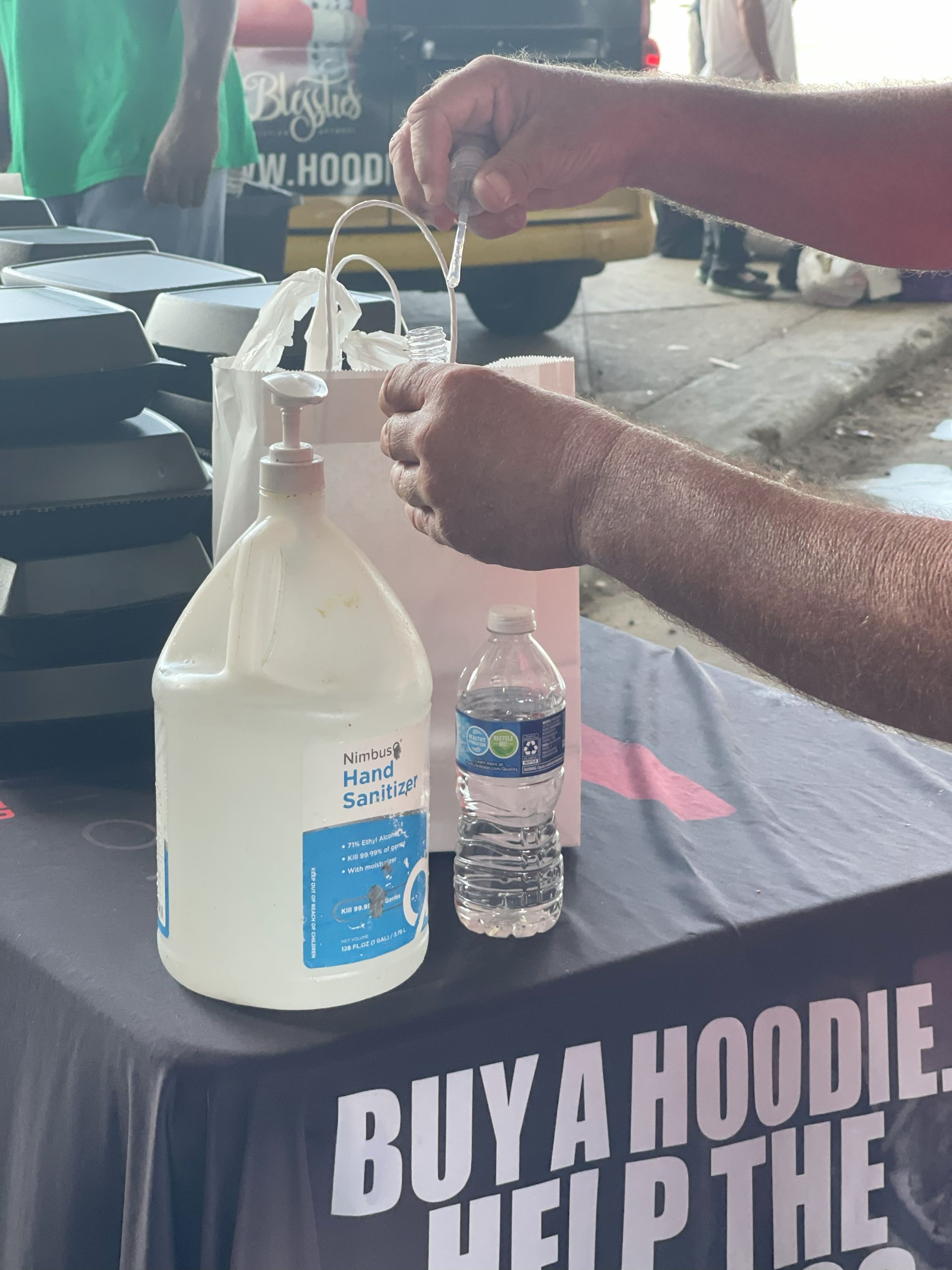 A table with a sign that says buy a hoodie help the