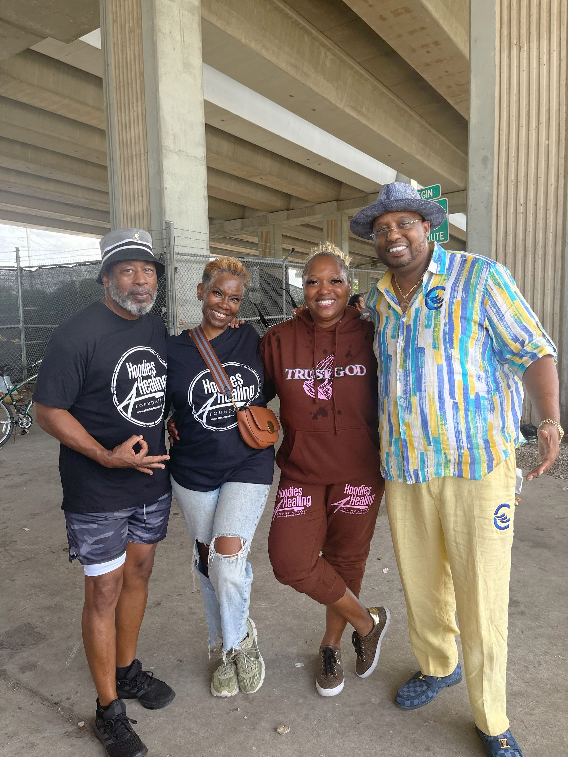 A group of people are posing for a picture under a bridge.