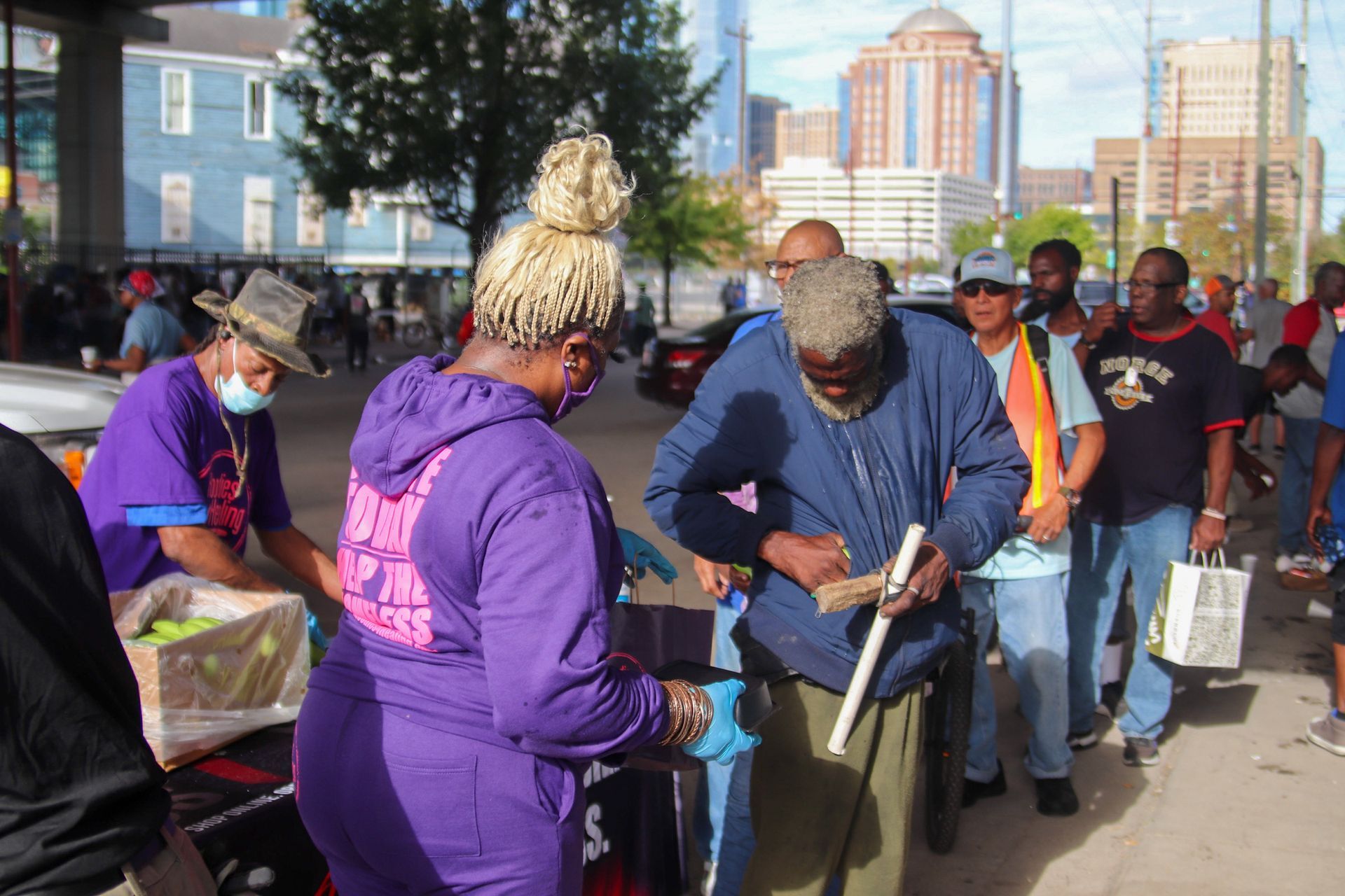 A woman in a purple hoodie is standing next to a man in a blue jacket.
