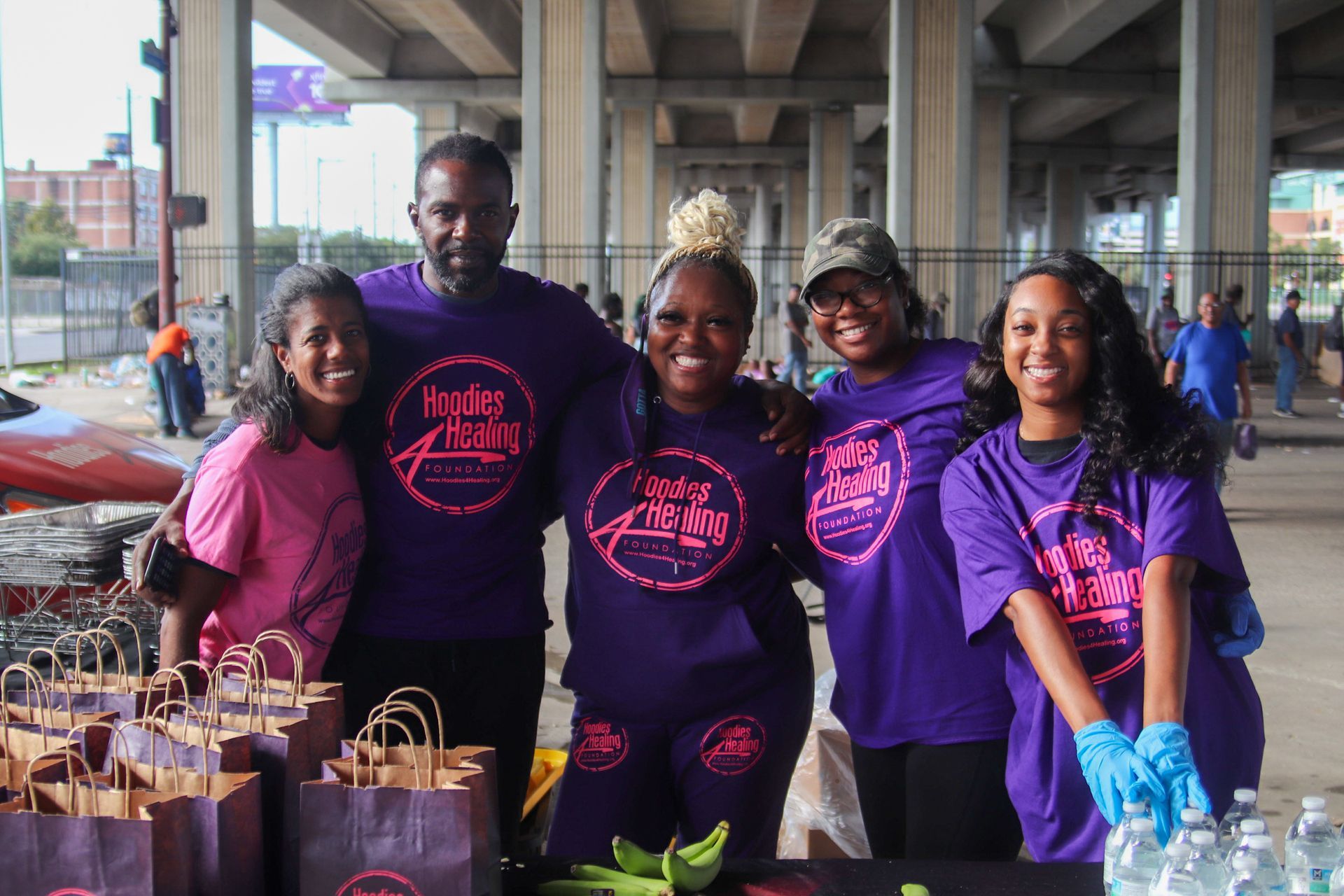 A group of people wearing purple shirts are posing for a picture.