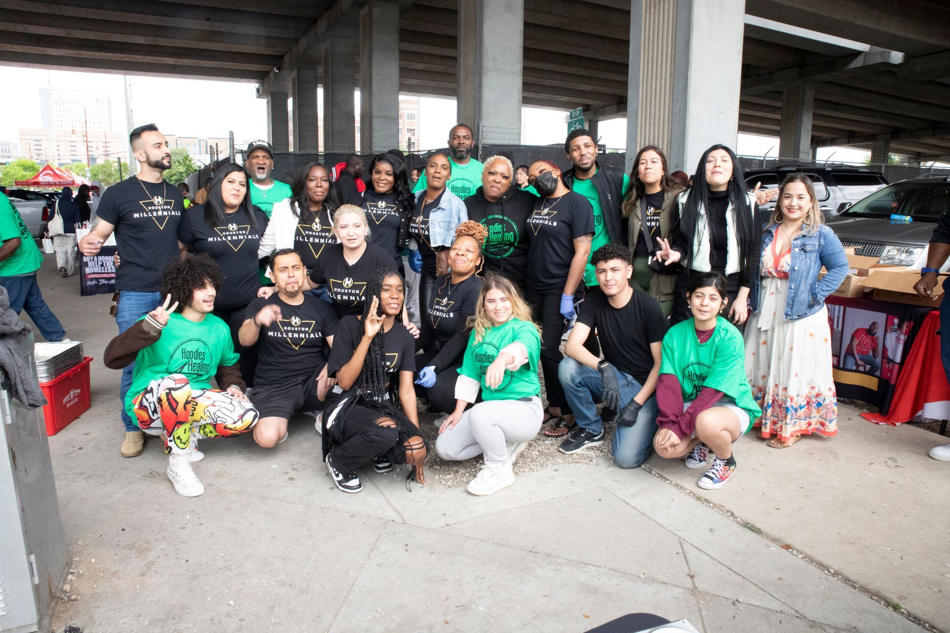 A group of people are posing for a picture under a bridge.