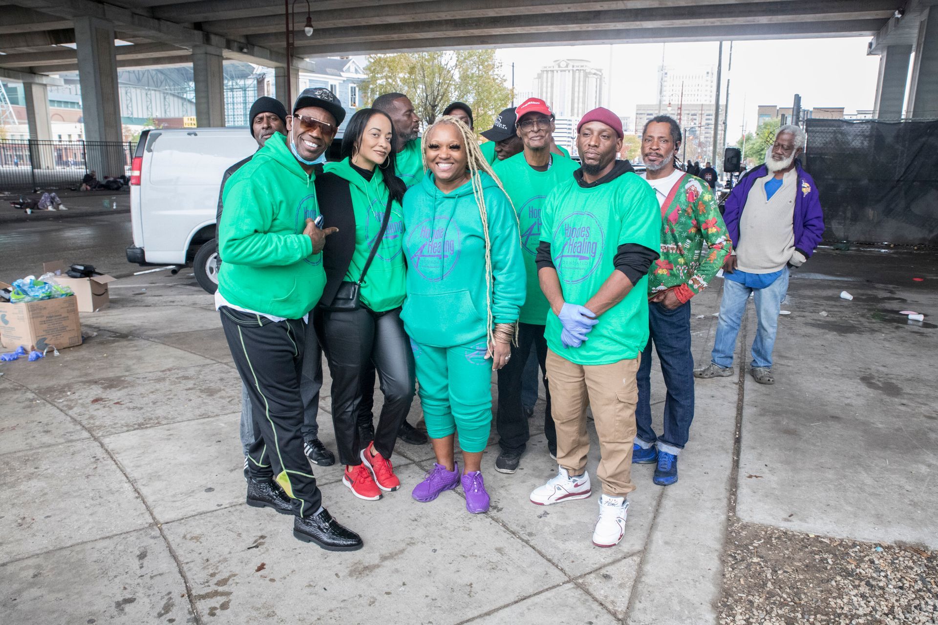 A group of people in green shirts are posing for a picture.
