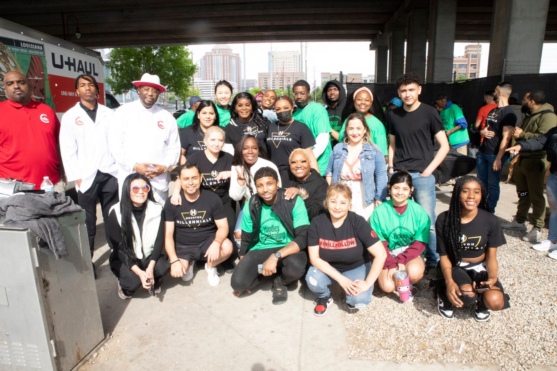 A group of people are posing for a picture under a bridge.