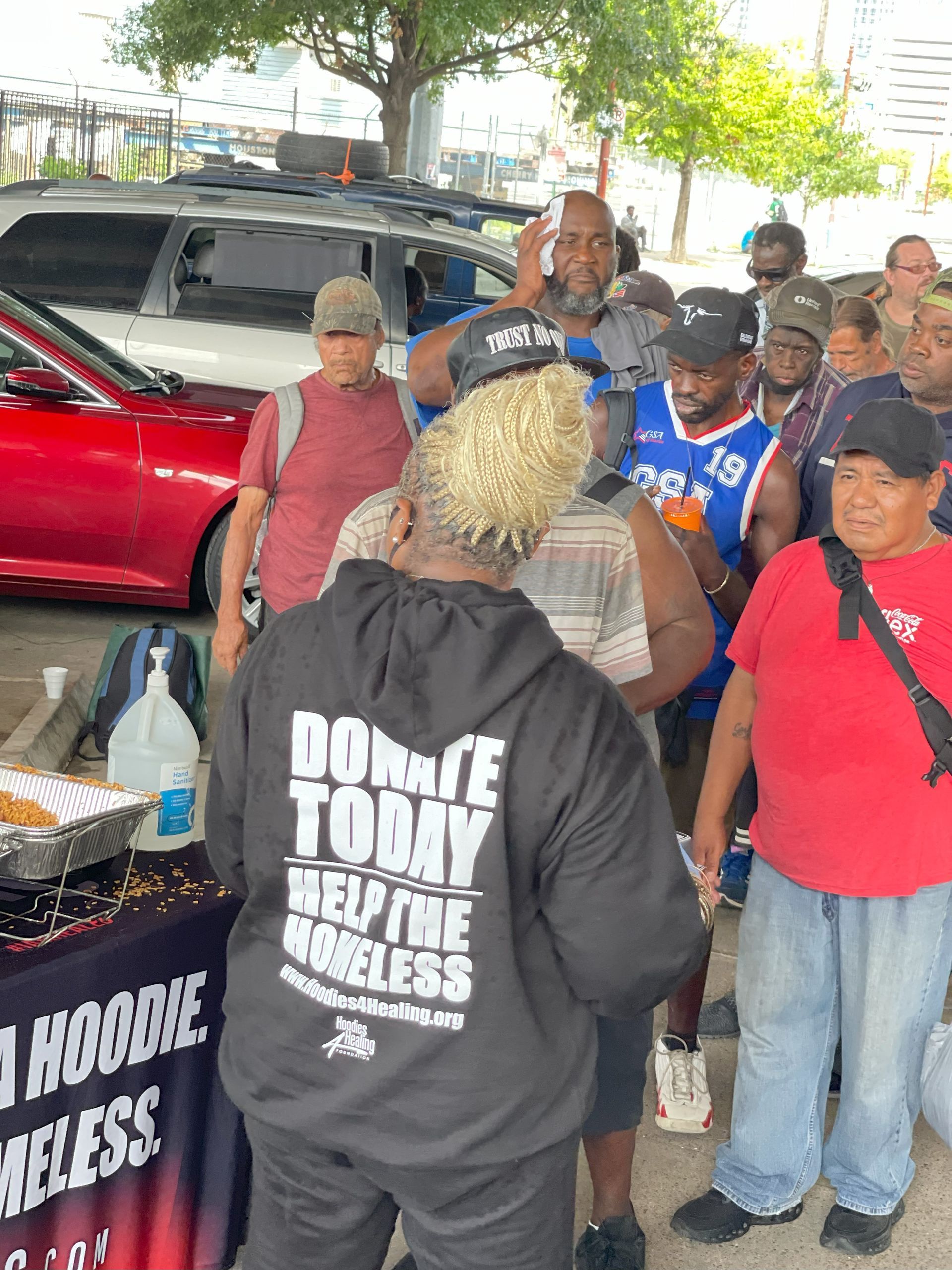 A group of people are standing around a table.