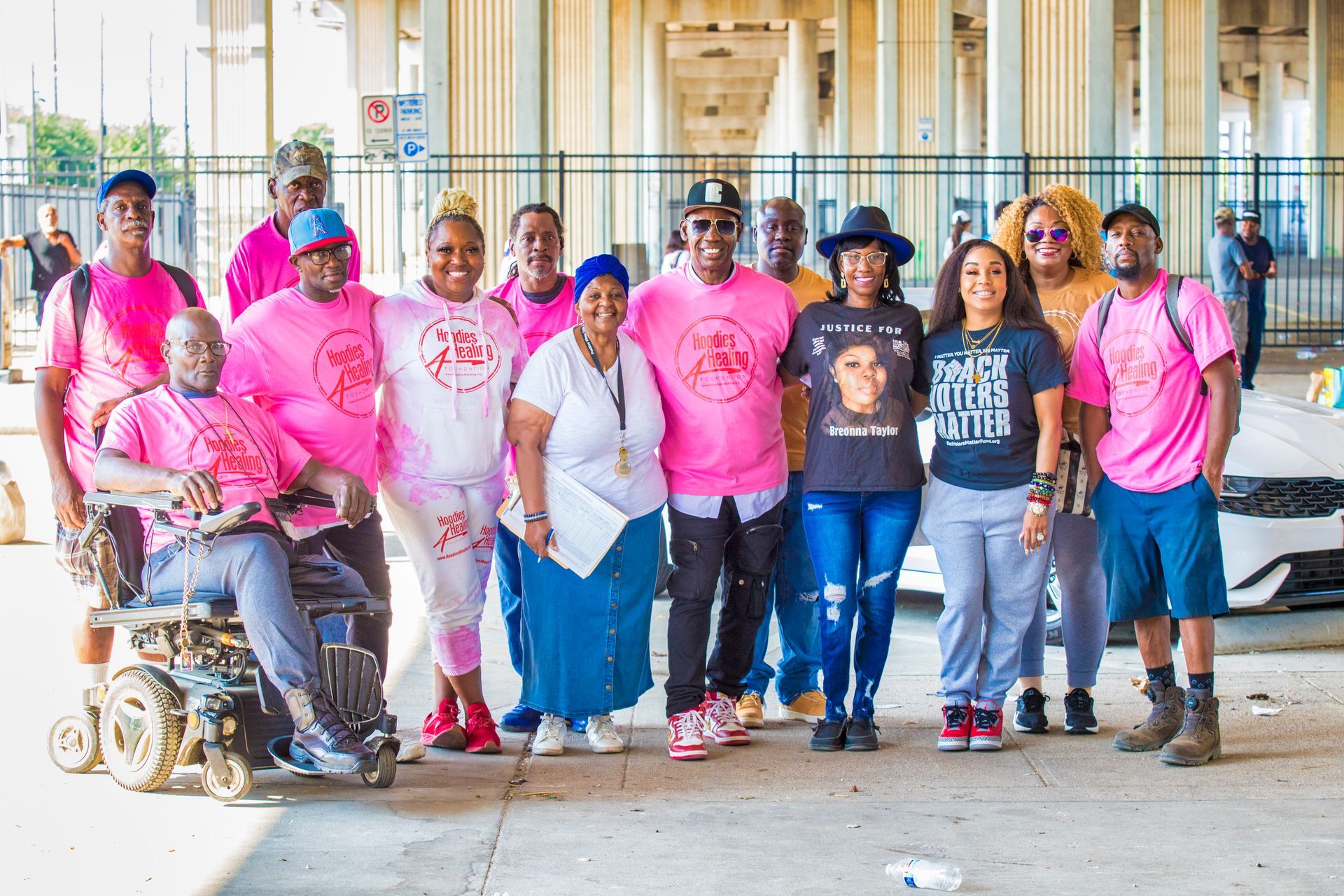 A group of people wearing pink shirts are posing for a picture.