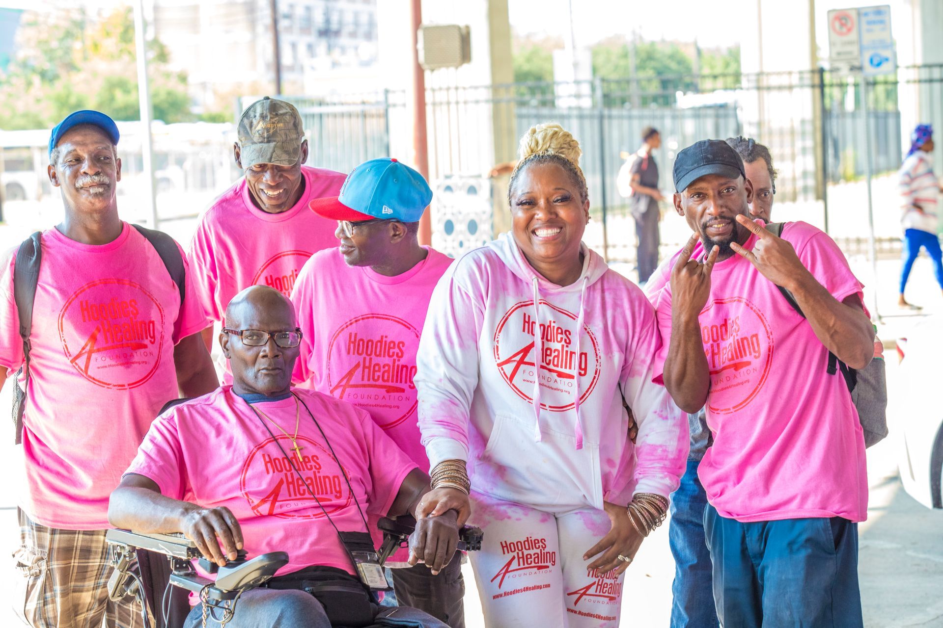 A group of people wearing pink shirts are posing for a picture.