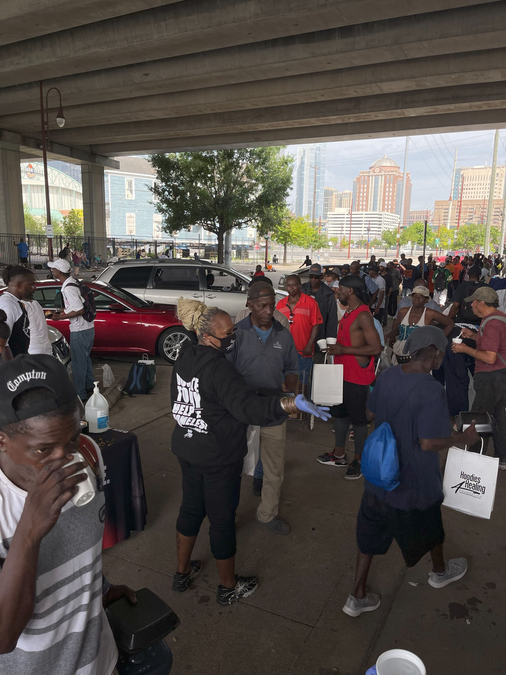 A group of people are standing under a bridge.